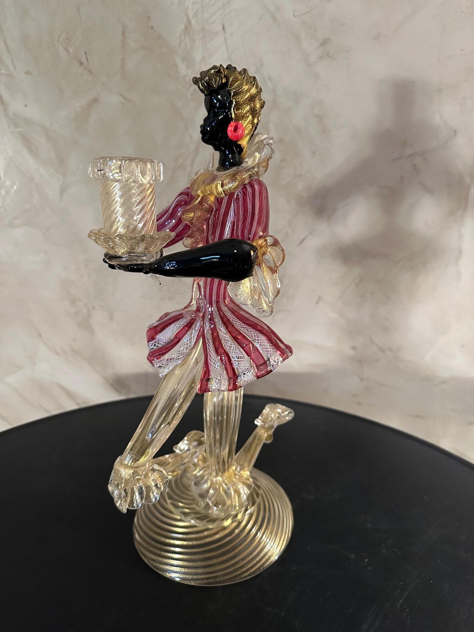 Murano glass candle holder by Vivarini representing a valet on one knee and holding the candle holder in his hand. dating from the 50s. 
Very good condition. For lovers of beautiful pieces and Murano.
Manufacturer's label below.