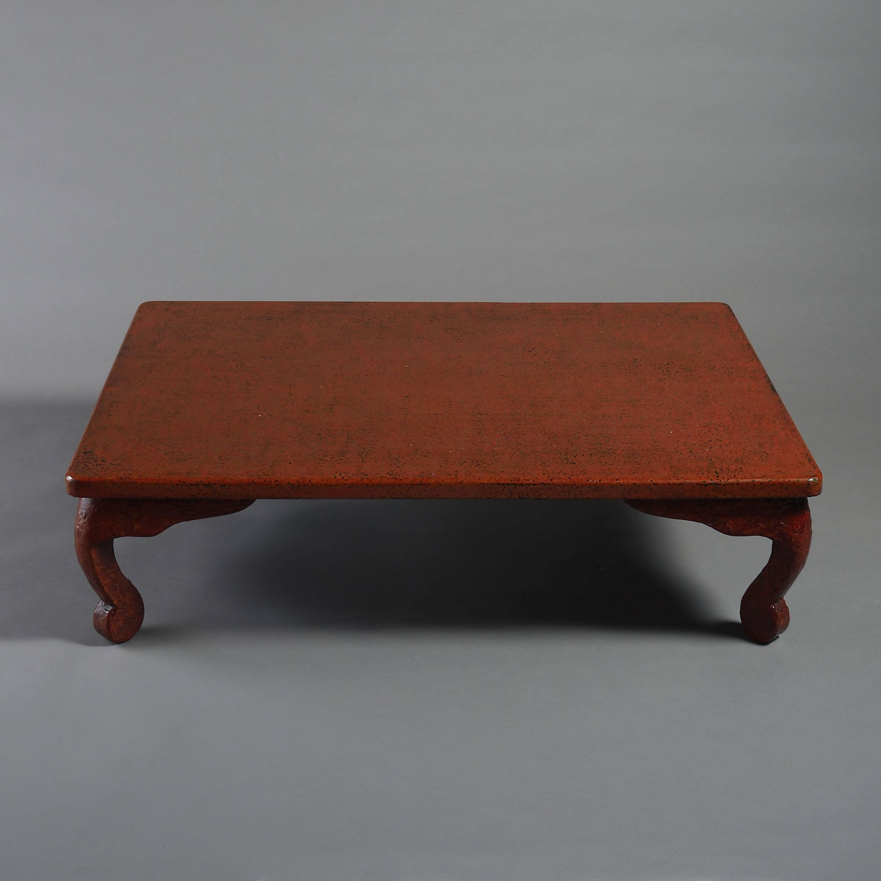 A 20th century red Wakasa-nuri lacquer low table, having a rectangular top, set upon scrolling feet.
 