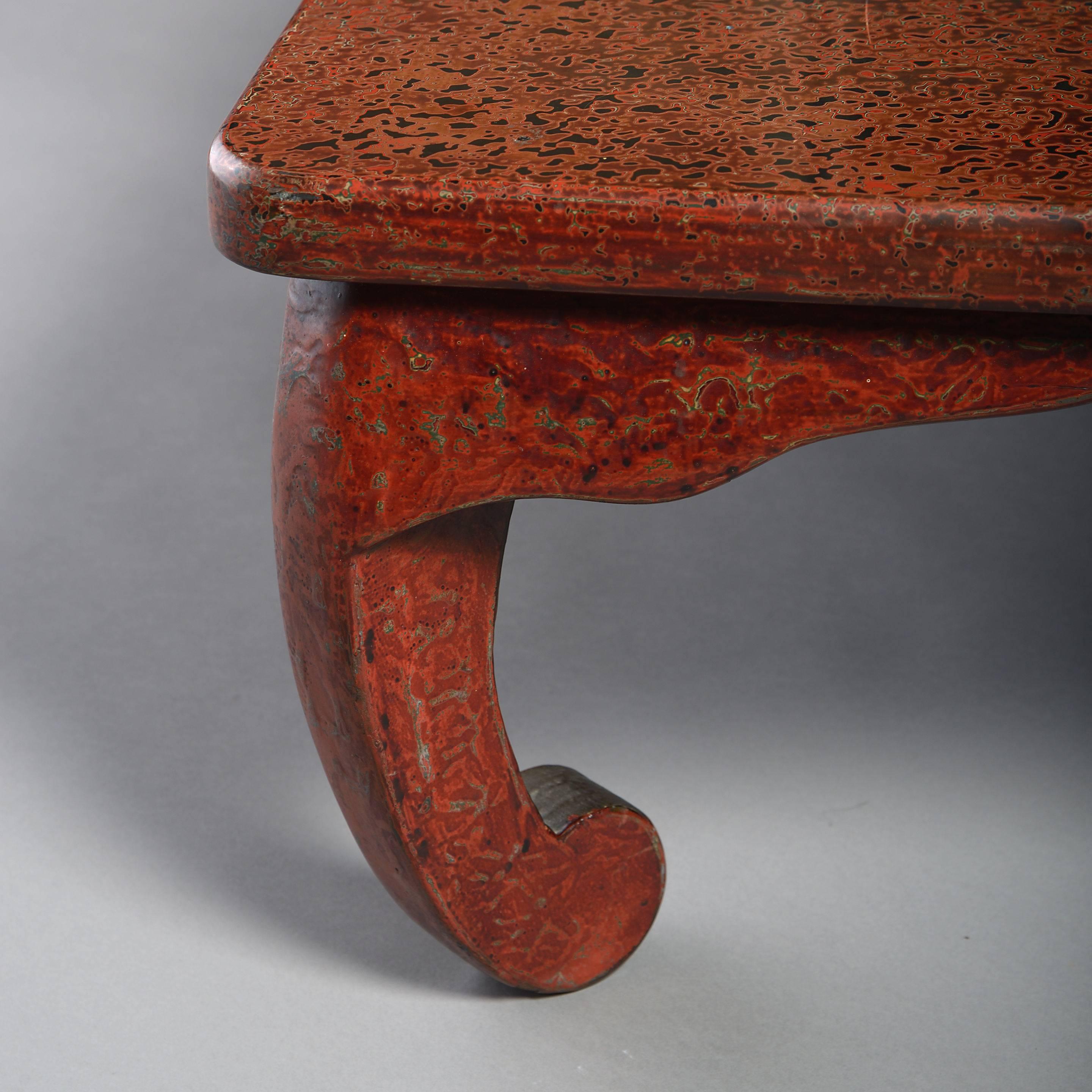 A mid-20th century Wakasa-nuri red lacquer low table, the rectangular top set upon four scrolling legs.