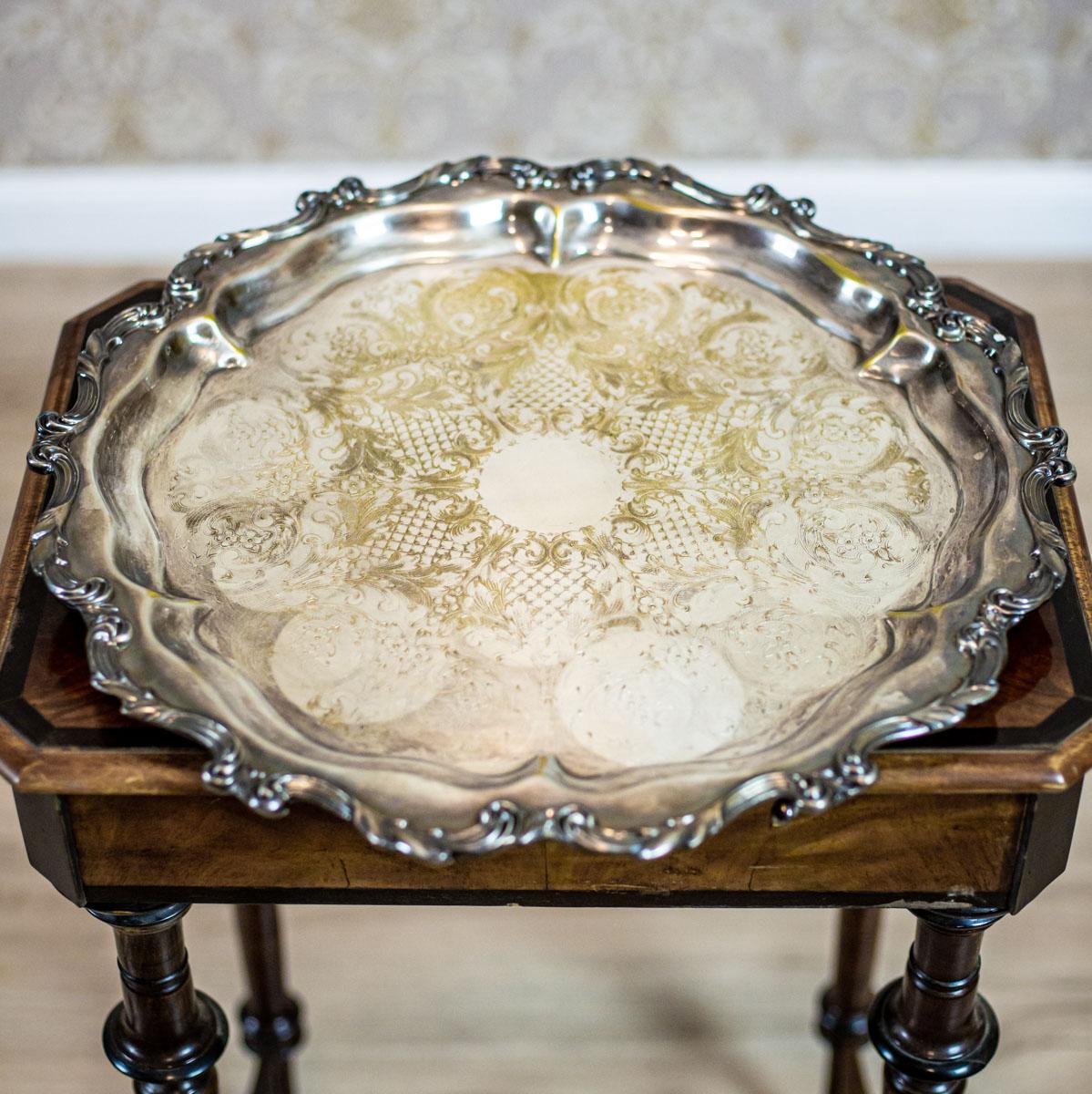 We present you a round, silver-plated tray by R. Wallace & Son, an American manufactory of ware and cutlery.
The whole item is placed on three legs. Its edges are wavy, the bottom is incised.

This tray is in good condition. The silver layer is