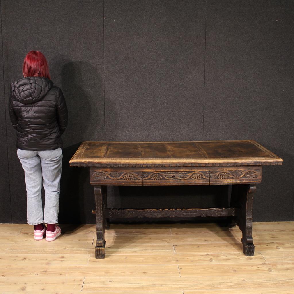 Italian writing desk from the mid-20th century. Rustic furniture in Valvaraita style, finely carved in walnut and fruitwood, in a beautiful patina. Finished for the center table equipped with a large central drawer and wooden top in character of