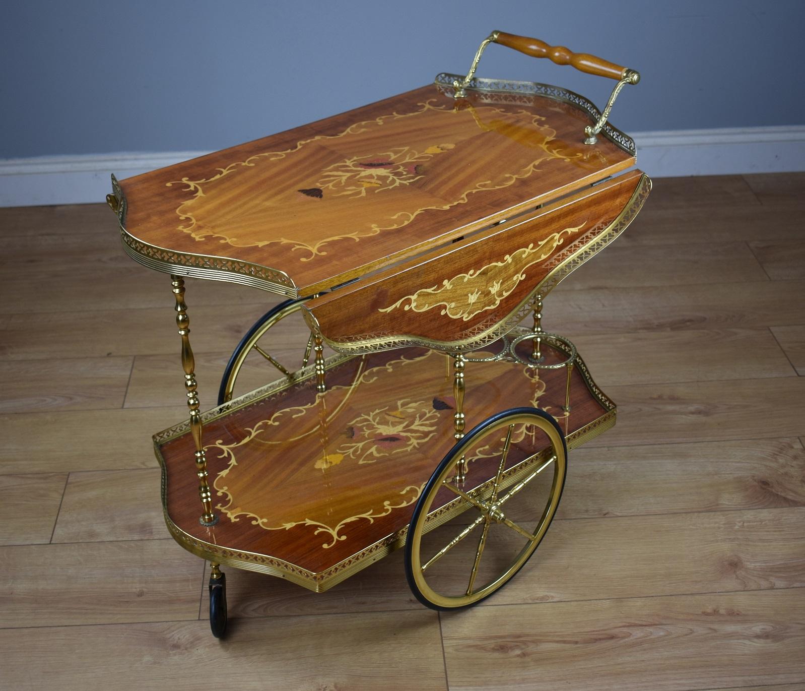 For sale is a good quality walnut and marquetry drinks trolley by H&L Epstein. The trolley has shaped drop leaves, profusely decorated with marquetry inlay above an under tier, fitted for bottles and decorated with further marquetry inlay. The