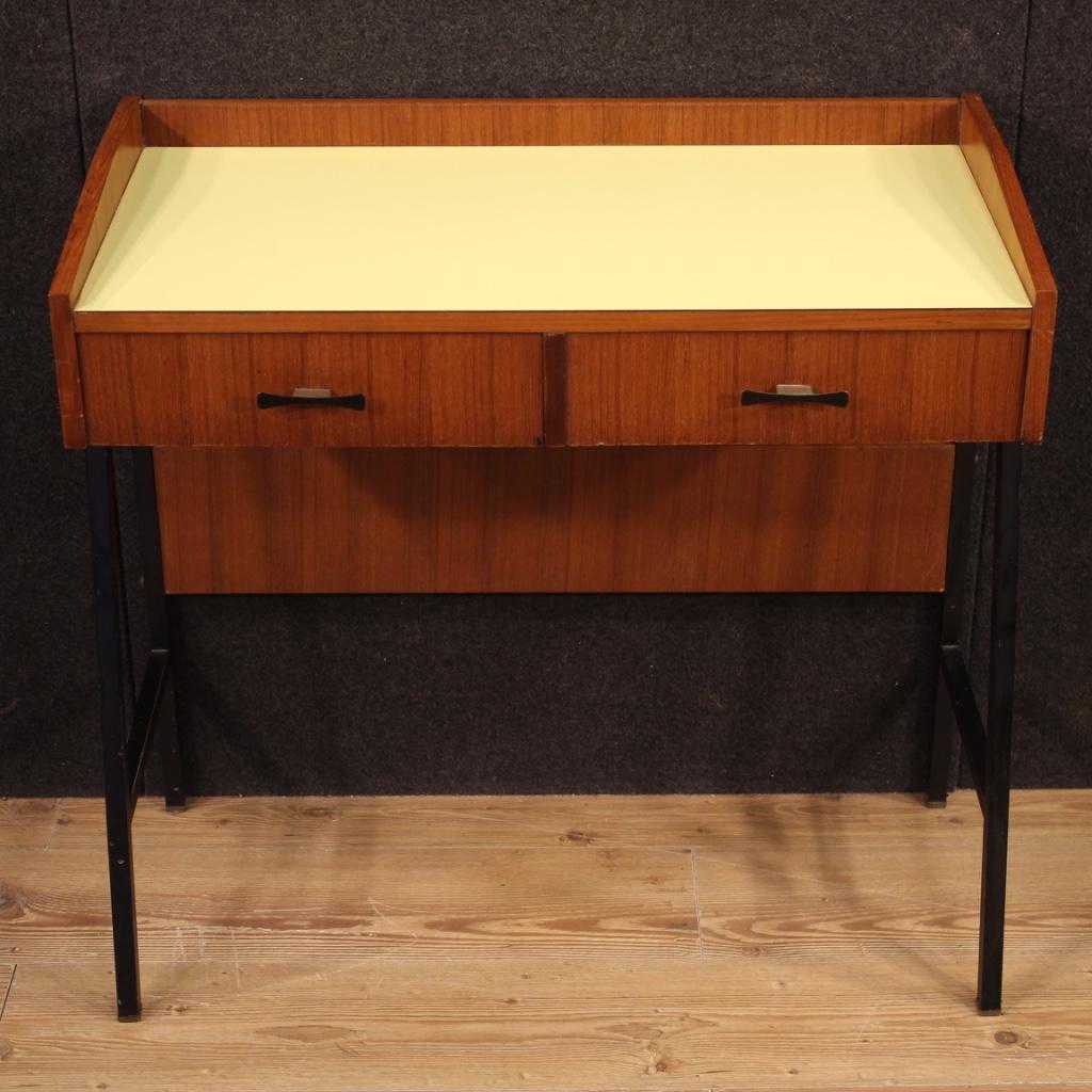 Italian design desk from the 1970s-1980s. Walnut veneered furniture supported laterally by a metal structure, of particular line and construction. Center finished desk equipped with two good capacity front drawers. It can be easily placed in