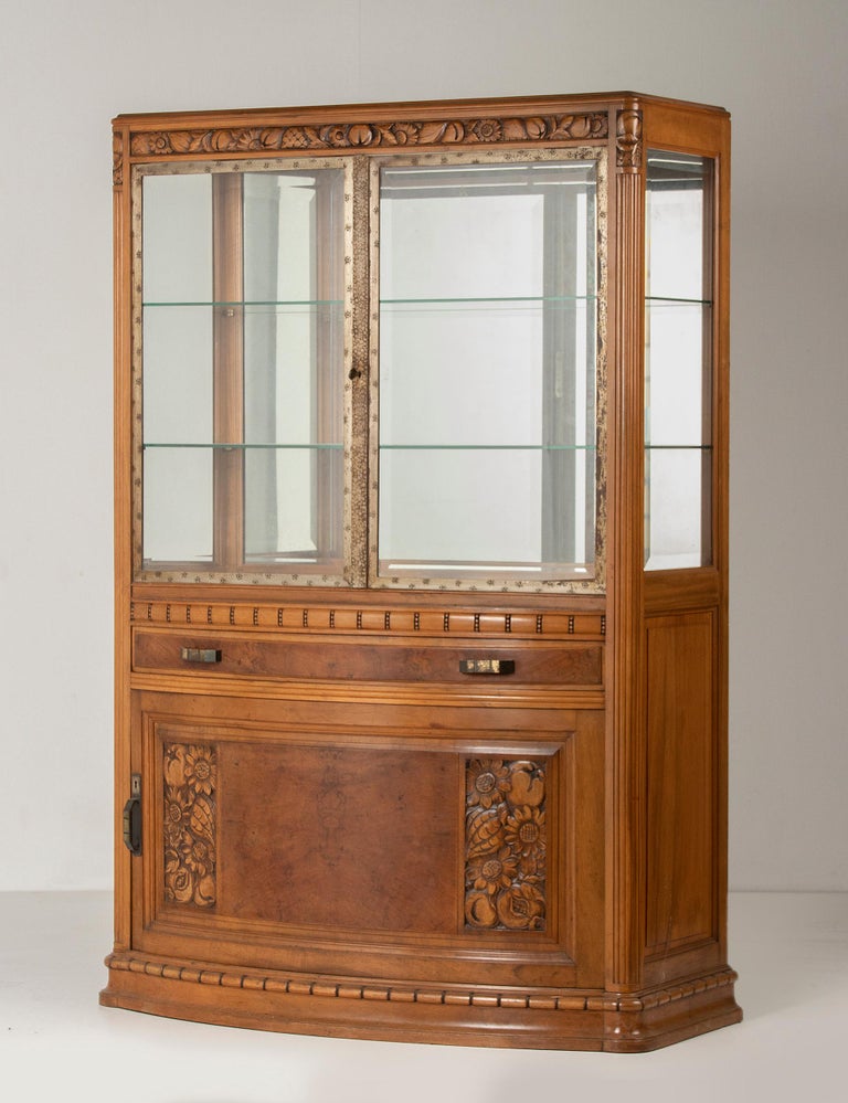 A French solid walnut display vitrine. The cabinet is made according to the French Art Deco school.
At the top are solid iron doors, these are beautifully chiseled on the edges. The glassware all around here beveled. Inside two glass shelves, these