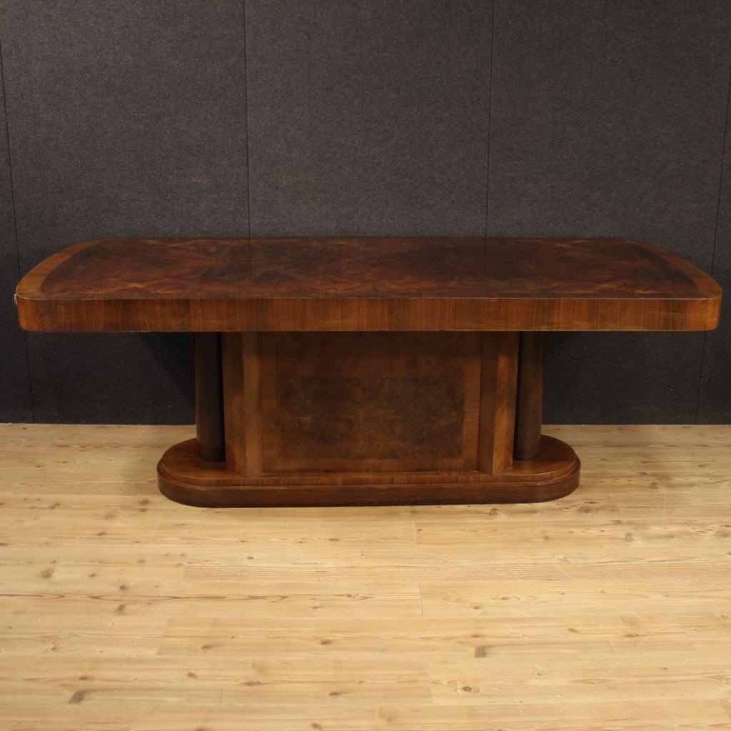 Large Italian table from the mid-20th century. High quality furniture in walnut, burl and palisander of fabulous decor. Living room table with particular central base with lateral columns (see photo). There are removable metal elements to support