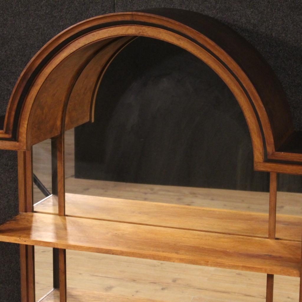 Italian étagère from the mid-20th century. Furniture carved in walnut, burl, oak, beech and ebonized wood of particular line and construction. Étagère fitted with three built-in mirrors and two shelves (plus base plate). Discreet service furniture