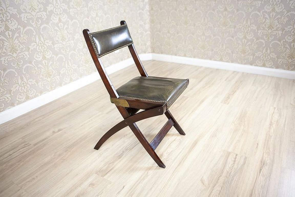20th-Century Walnut Folding Chair Upholstered With Dark-Green Leather

We present you a folding walnut chair from the 1st half of the 20th century. 
The seat and backrest are lined with dark-green leather. 
The leather fastening finished with