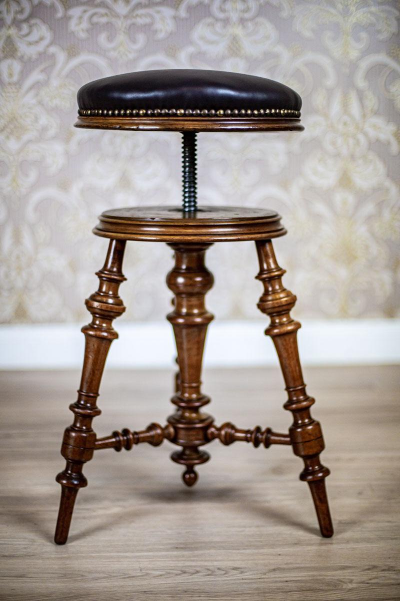 We present you a walnut stool from the early 20th century with a leather seat.
This piece of furniture is placed on three rounded legs connected with stretchers.
The central pivot hides a thread to adjust the height of the seat.

Presented stool