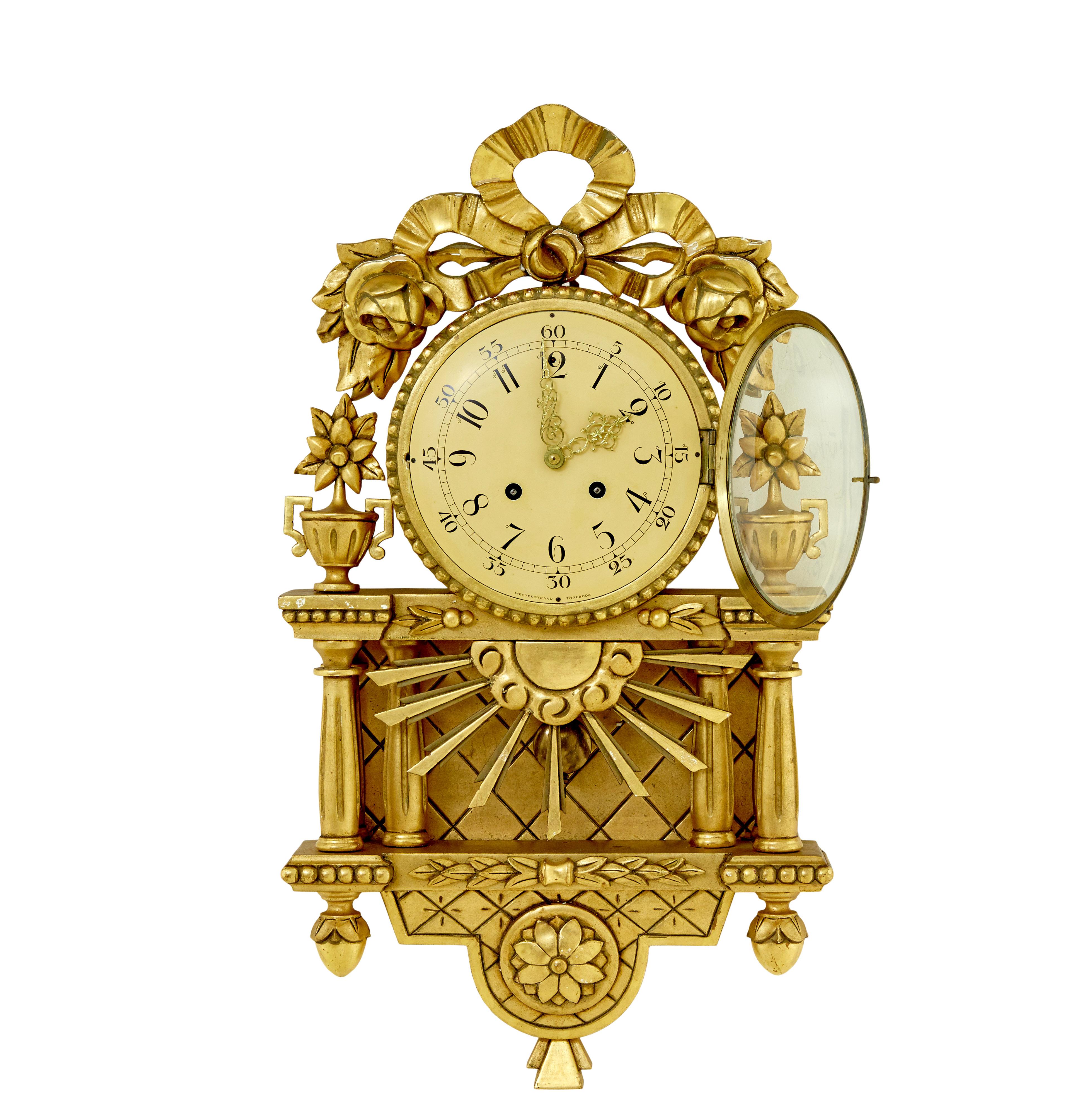 Good quality rococo influenced clock by well known Swedish maker Westerstrand.

Fitted with a twin train 8 day movement and original pendulum. Enamel clock face with arabic numerals and ornate pierced hands, carved swags mounted to top of clock