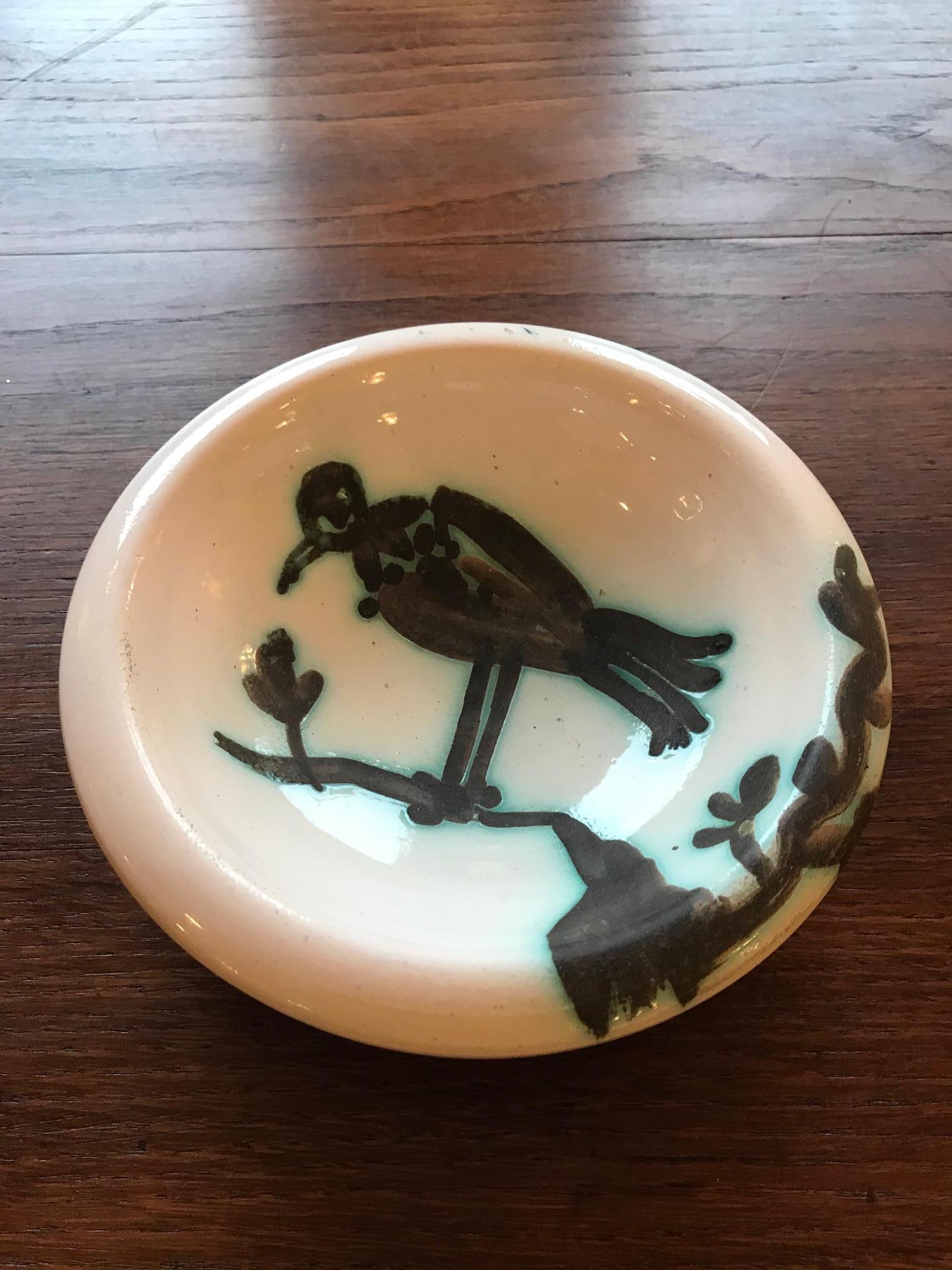Very nice 20th century white Earthenware Picasso ashtray from the 1950s representing a bird on a branch. Decorated with oxidized paraffin. White enamel. Black decor.
Edition of 500 copies.
Picasso Edition Stamp at the back.
Bibliography: Ramié n
