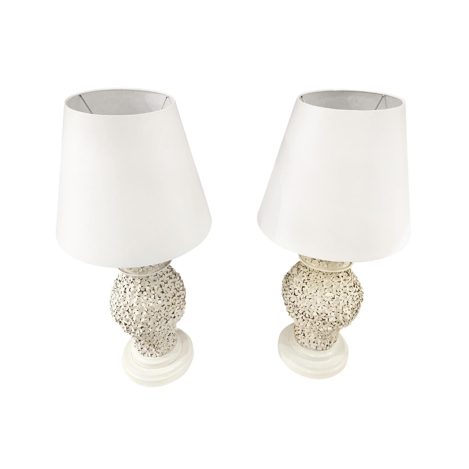 A white, vintage Art Deco French pair of tall table lamps with a new white round shade, made of hand crafted porcelain and metal, in good condition. The sculptural lights are particularized by floral decoration, featuring a two light socket. The