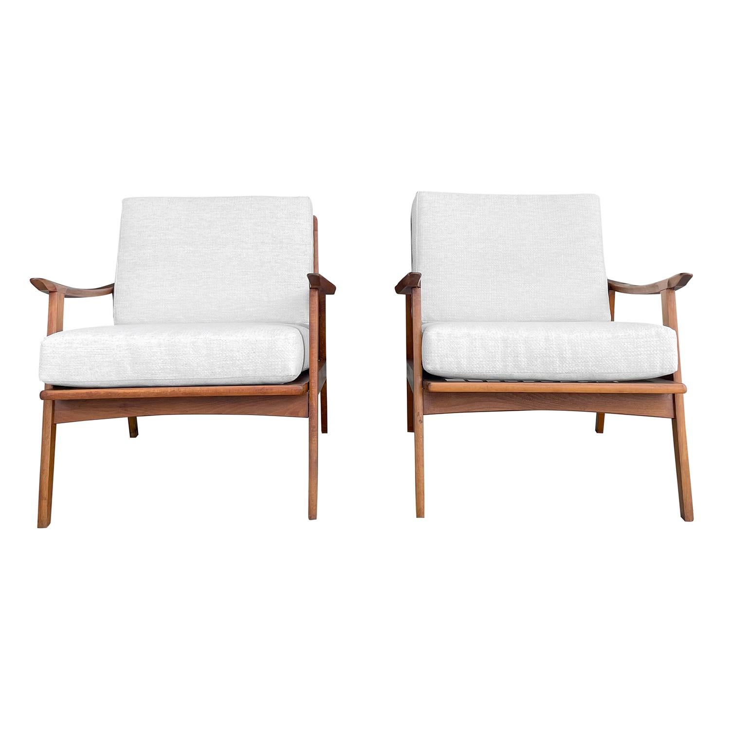 A vintage Mid-Century modern Danish pair of open armchairs made of hand crafted polished Teakwood, designed by Kai Kristiansen in good condition. The back rest of the Scandinavian low back lounge chairs are spindled and curved with slim, arched