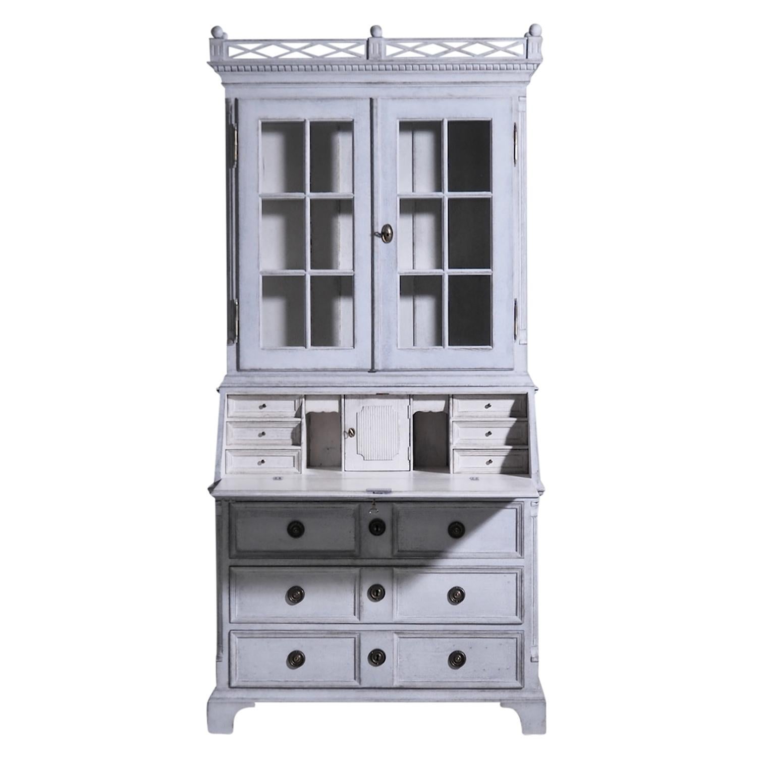 A light-grey, white antique Swedish Gustavian two part bureau with a writing flap made of hand crafted painted Pinewood, in good condition. The Scandinavian secretaire is composed with two upper doors, three large drawers and many small storage