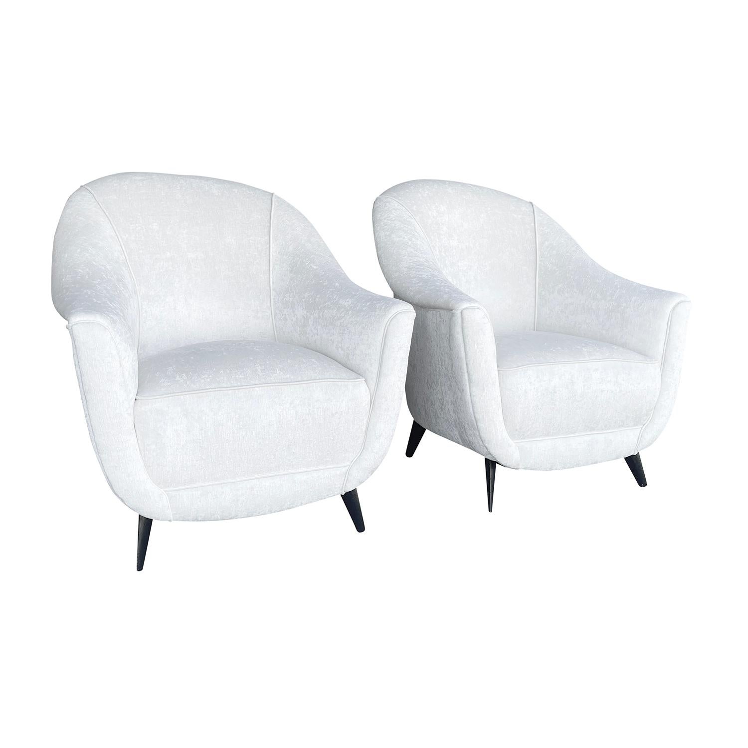 A white, vintage Mid-Century Modern Italian pair of club chairs designed most likely Marco Zanuso, in good condition. The backrest of the small corner, lounge chairs are slightly leaned to the back with outstretched arms, supported by four curved