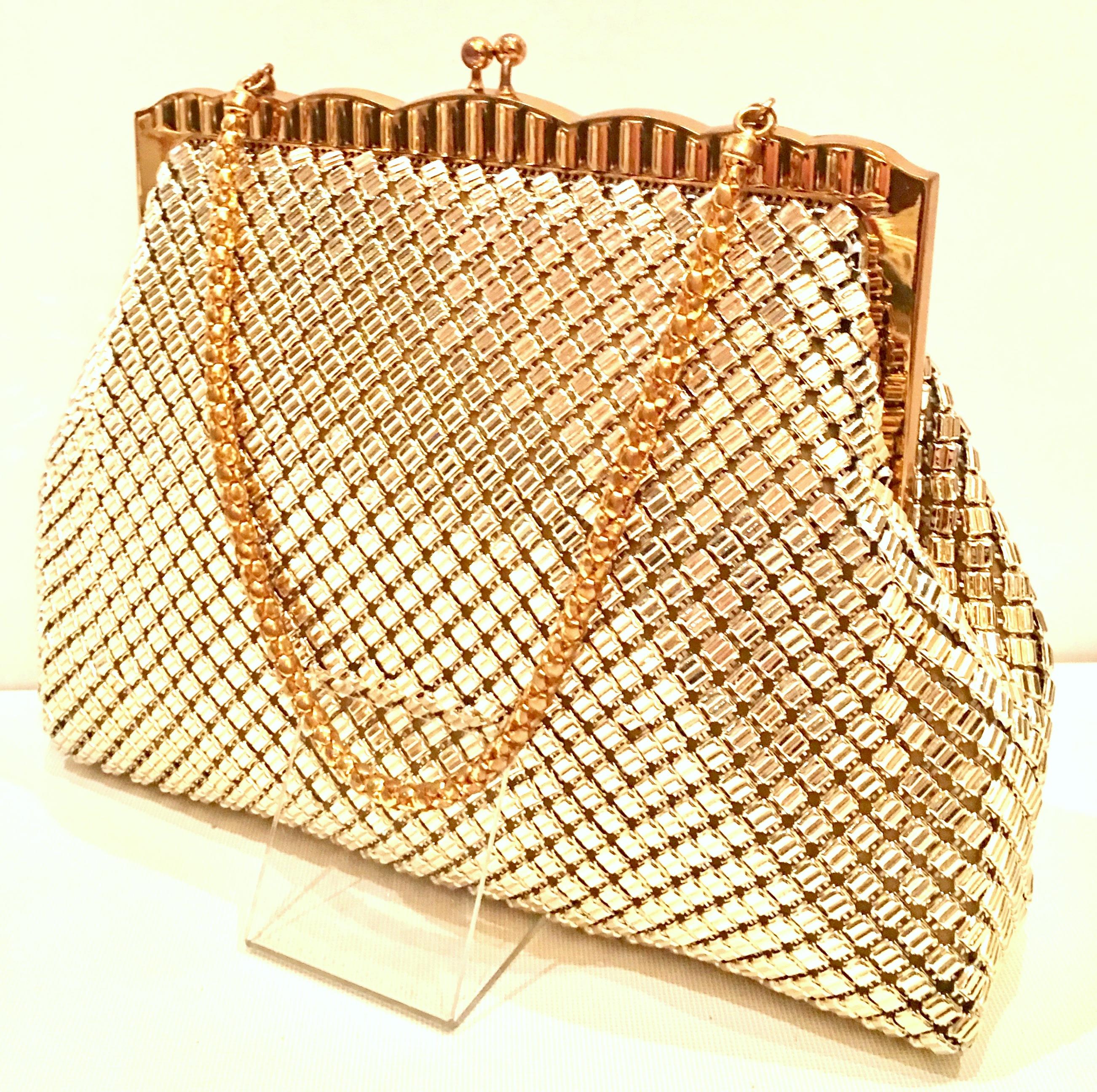 Mid-20th Century Whiting & Davis Gold Metal Mesh Handbag. This older, unique and pristine metal mesh handbag features a gilt gold metal frame with a soft metal mesh body and gilt gold rope style shoulder carrying strap. The interior pristine, has