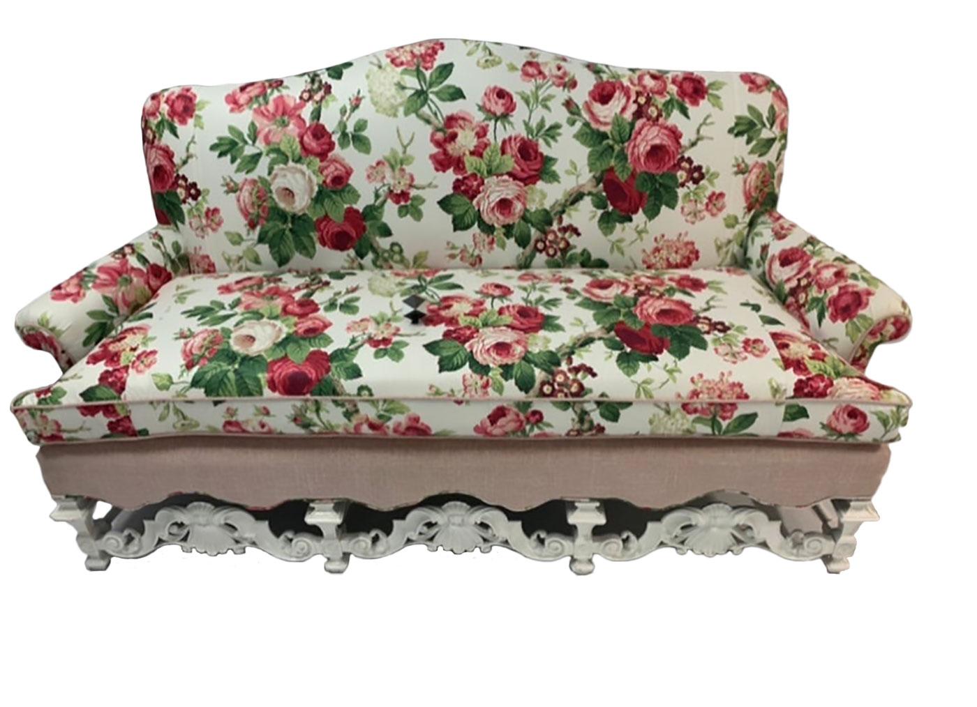 20th century William & Mary style arched back sofa with highly carved front stretcher with scroll and fan motif. The sofa has rolled arms and consists of a single seat cushion reupholstered in Schumacher Chintz and a complimentary pink woven fabric.