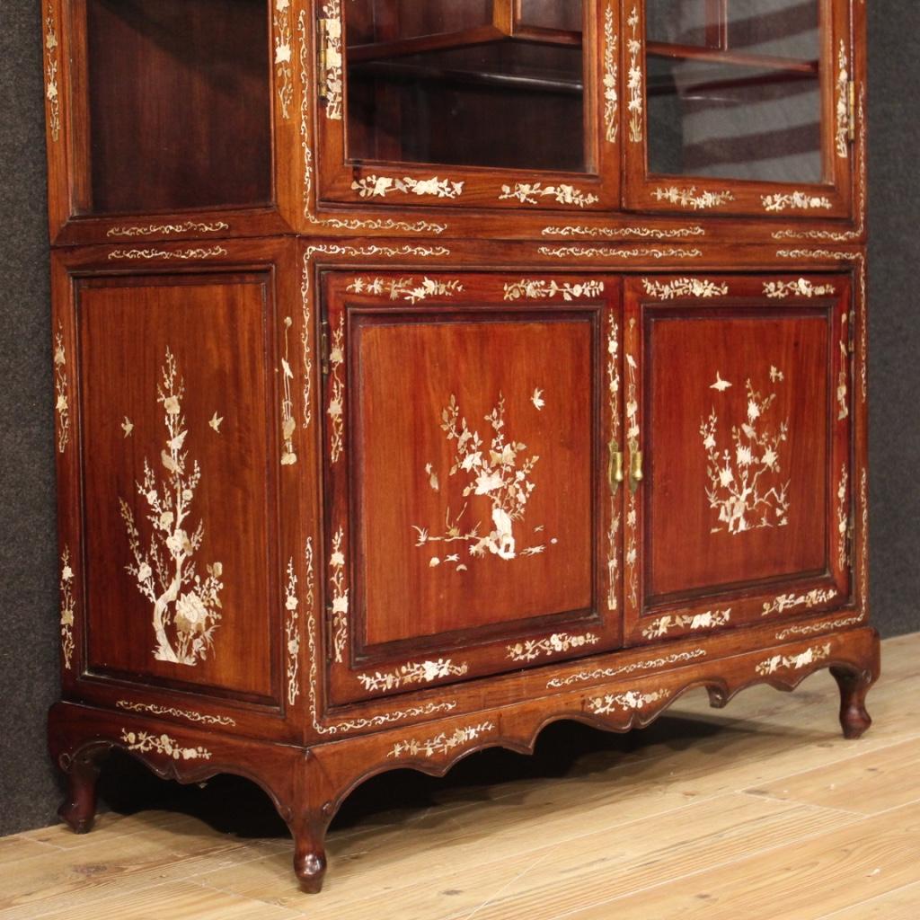 Oriental showcase from the mid-20th century. Furniture of exceptional quality carved in mahogany and exotic woods adorned with rich inlay in faux mother of pearl with floral decorations. Display cabinet with two doors in the upper part and two