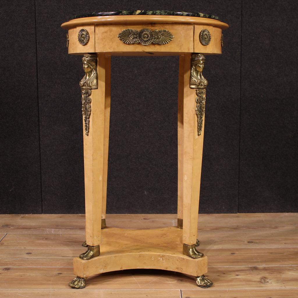 Table d'appoint française de la seconde moitié du XXe siècle. Meubles de style Retour d'Egypte, plaqués en racine de thuya, avec des éléments en hêtre, richement ornés de décorations métalliques dorées et ciselées. Dessus en marbre de bonne taille