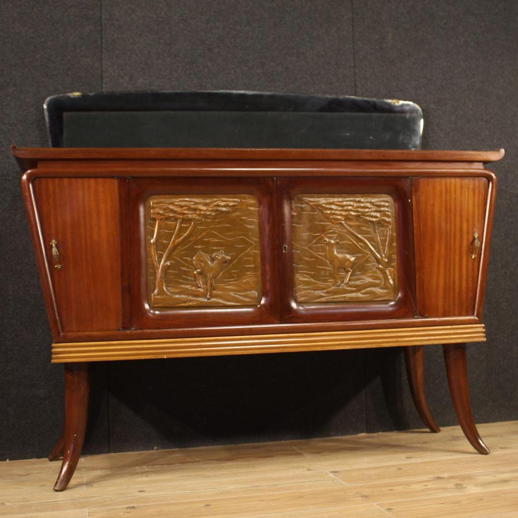 Italian design sideboard from the 1950s-1960s. High quality furniture carved and veneered in mahogany, walnut, beech and fruitwood. Sideboard with four doors, of good capacity, complete with a working key. Wooden top in character, of good size and