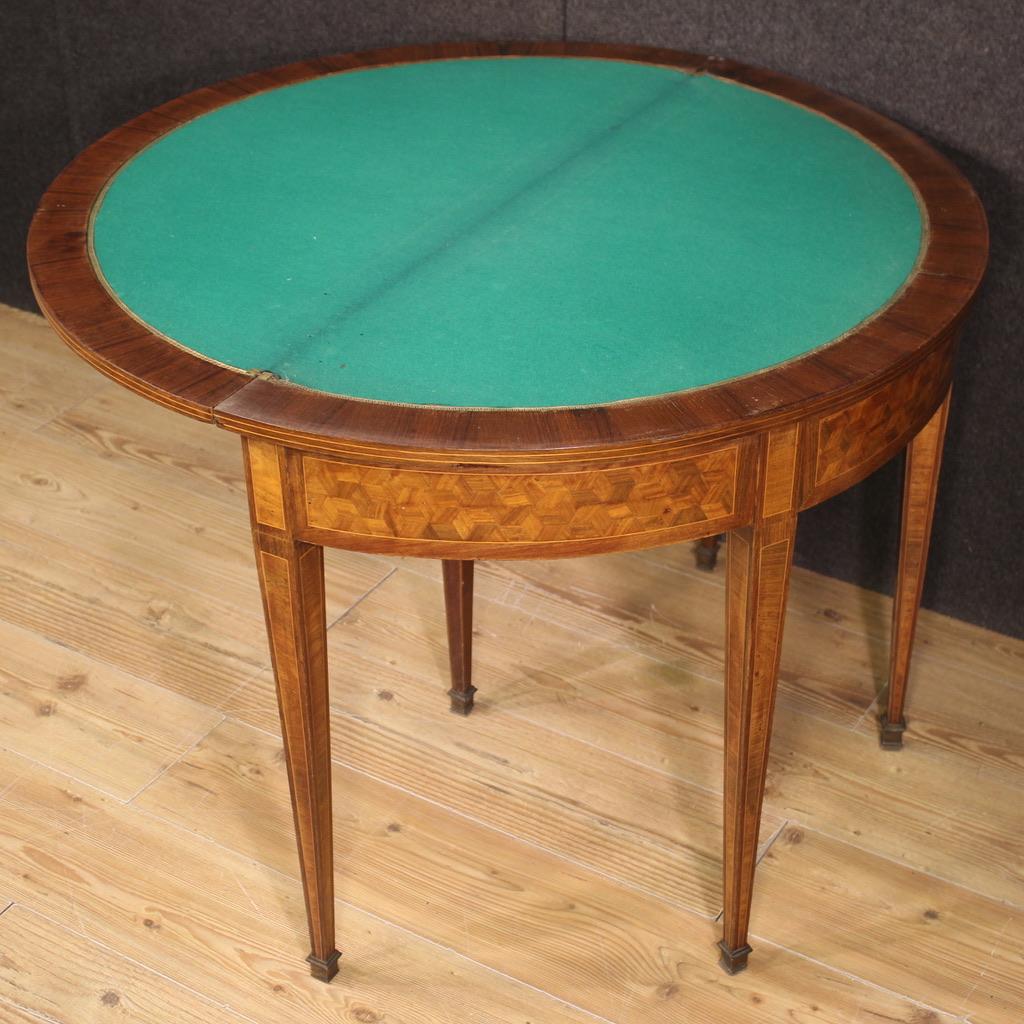 French game table console from the first half of the 20th century. Demilune cabinet inlaid with geometric decorations in walnut, mahogany, rosewood, maple and fruit wood. Opening table which offers, once opened, a play surface covered in fabric with