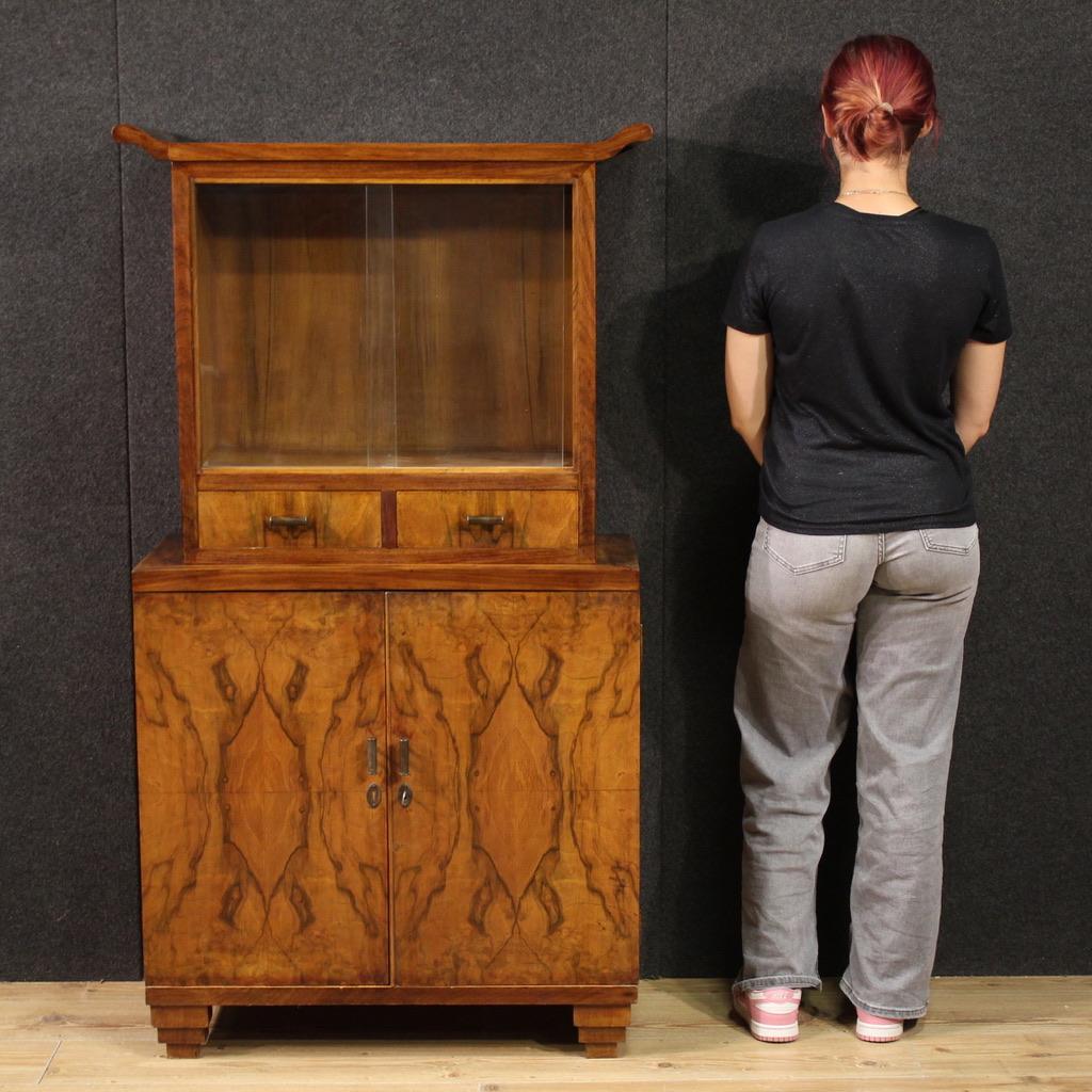 Mid-20th-century Italian display cabinet. Art Deco-style furniture veneered in walnut, burl walnut, mahogany, and fruitwood, of beautiful lines and attractive furnishings. The double-body cabinet features two lower doors, an internal shelf, and a