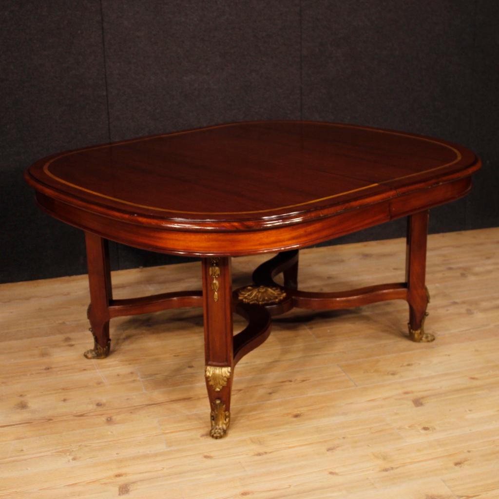 French leaf table from the early 20th century. Furniture carved in mahogany wood with inlay in maple and fruitwood richly adorned with gilded and chiselled bronzes. Dining table or living room table of great measure and service. Furniture which,