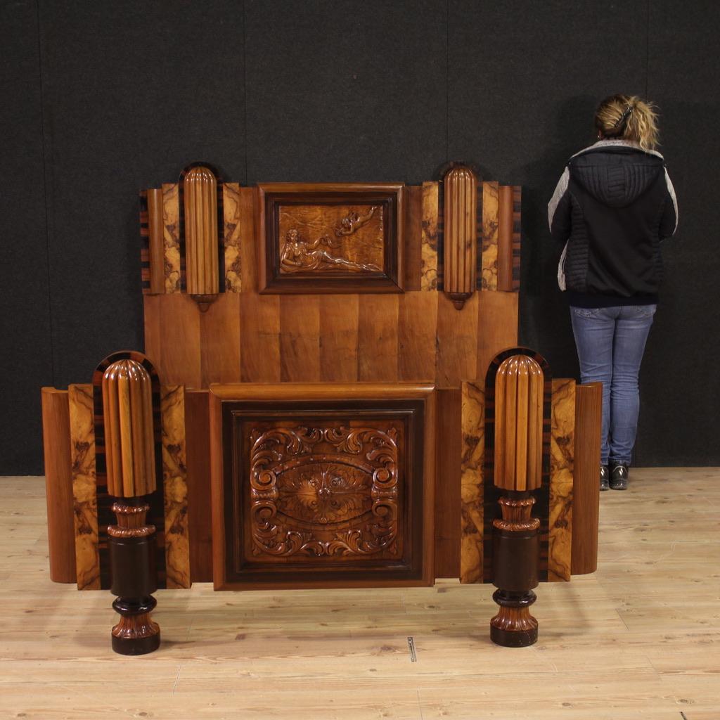 Fabulosa cama de matrimonio italiana de la época Art Déco (1930). Finamente tallado y chapado en madera de nogal, nogal africano, nudo y frutal de gran calidad. Impresionante cabecero con decoraciones laterales en relieve y panel central tallado con