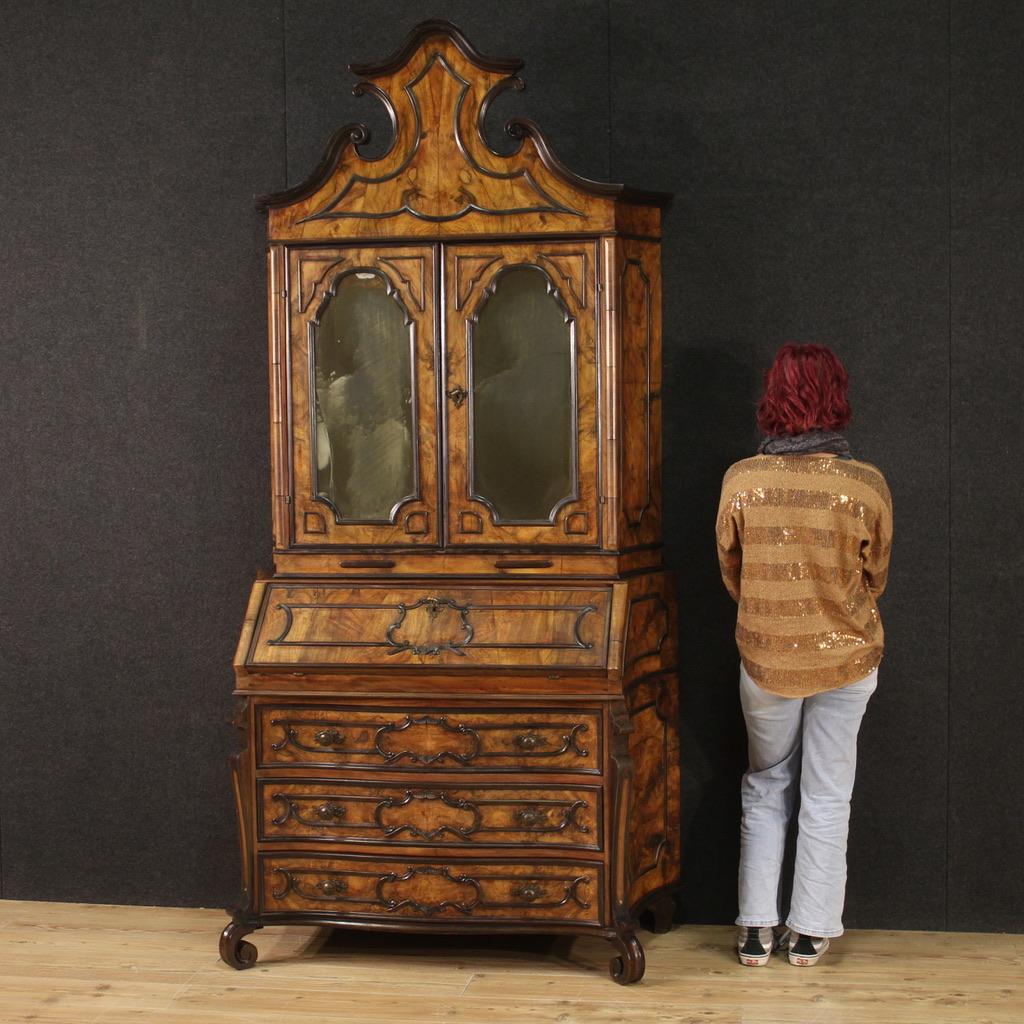 Elegant mid-20th century Lombard trumeau. Double body cabinet in Baroque style carved in walnut, ebonized wood and fruitwood. Trumeau for living room or study equipped with three drawers and fall-front in the lower body. Bureau that offers inside
