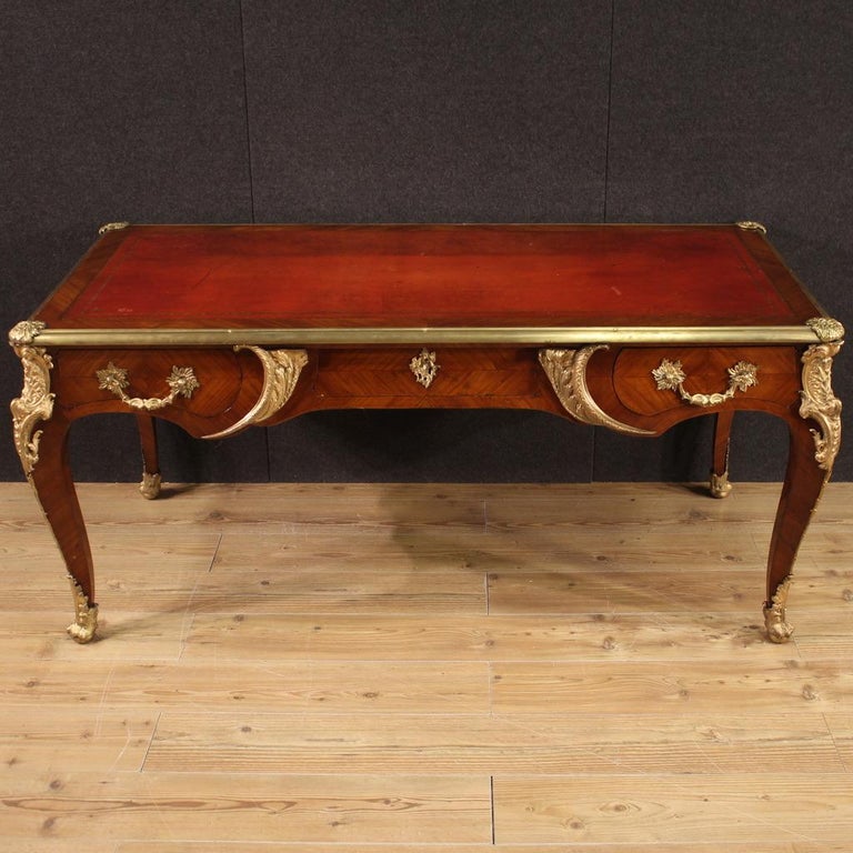 Great French writing desk of the first half of the 20th century. Louis XV style furniture in walnut, mahogany and oak richly adorned with gilded and chiseled bronze and brass of excellent quality. Desk finished from the center equipped with three