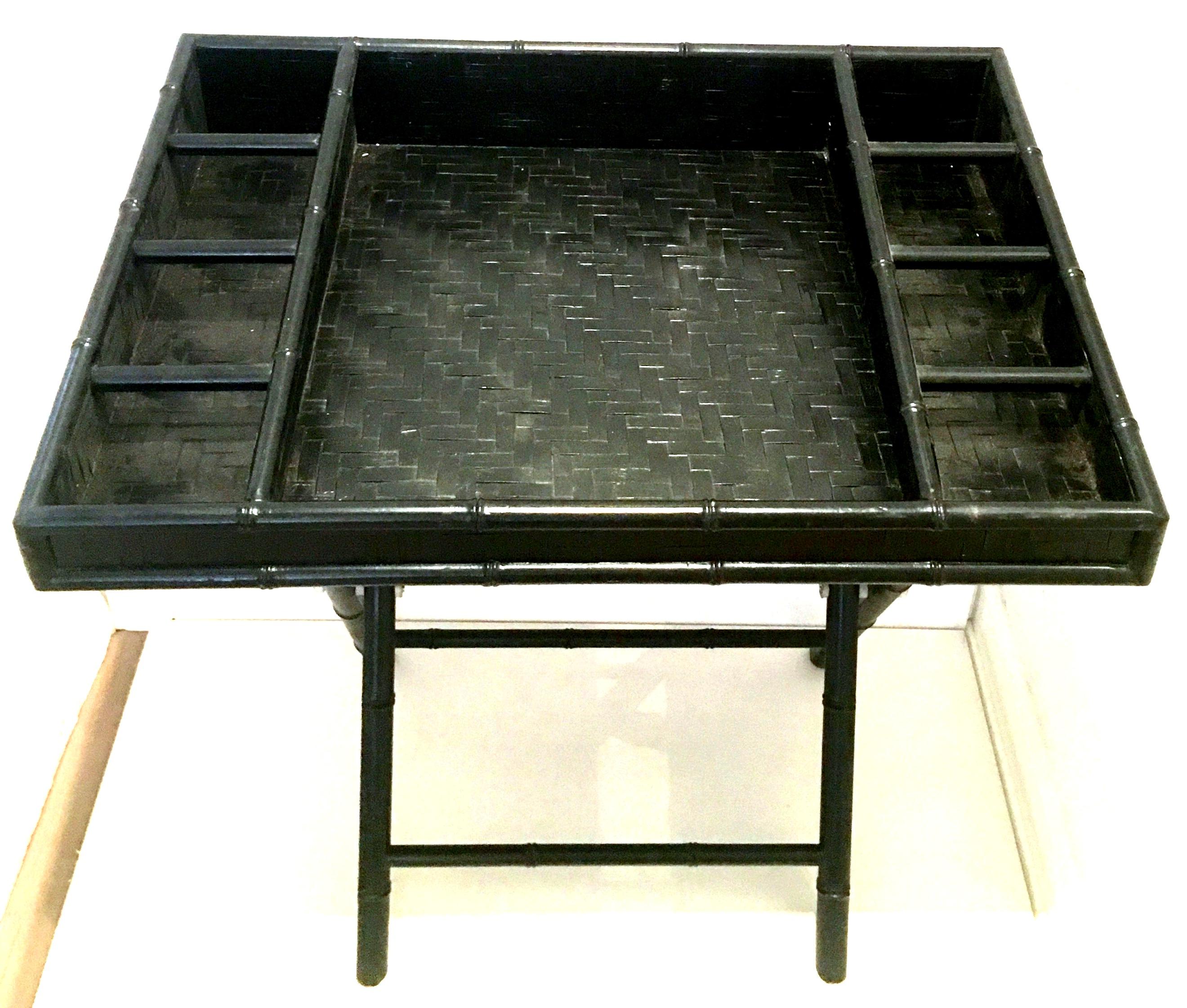 20th Century Campaign style Faux bamboo wood, rattan, wicker and steel folding  portable writing desk. This unique and clever piece painted black, consists of two pieces. The top 