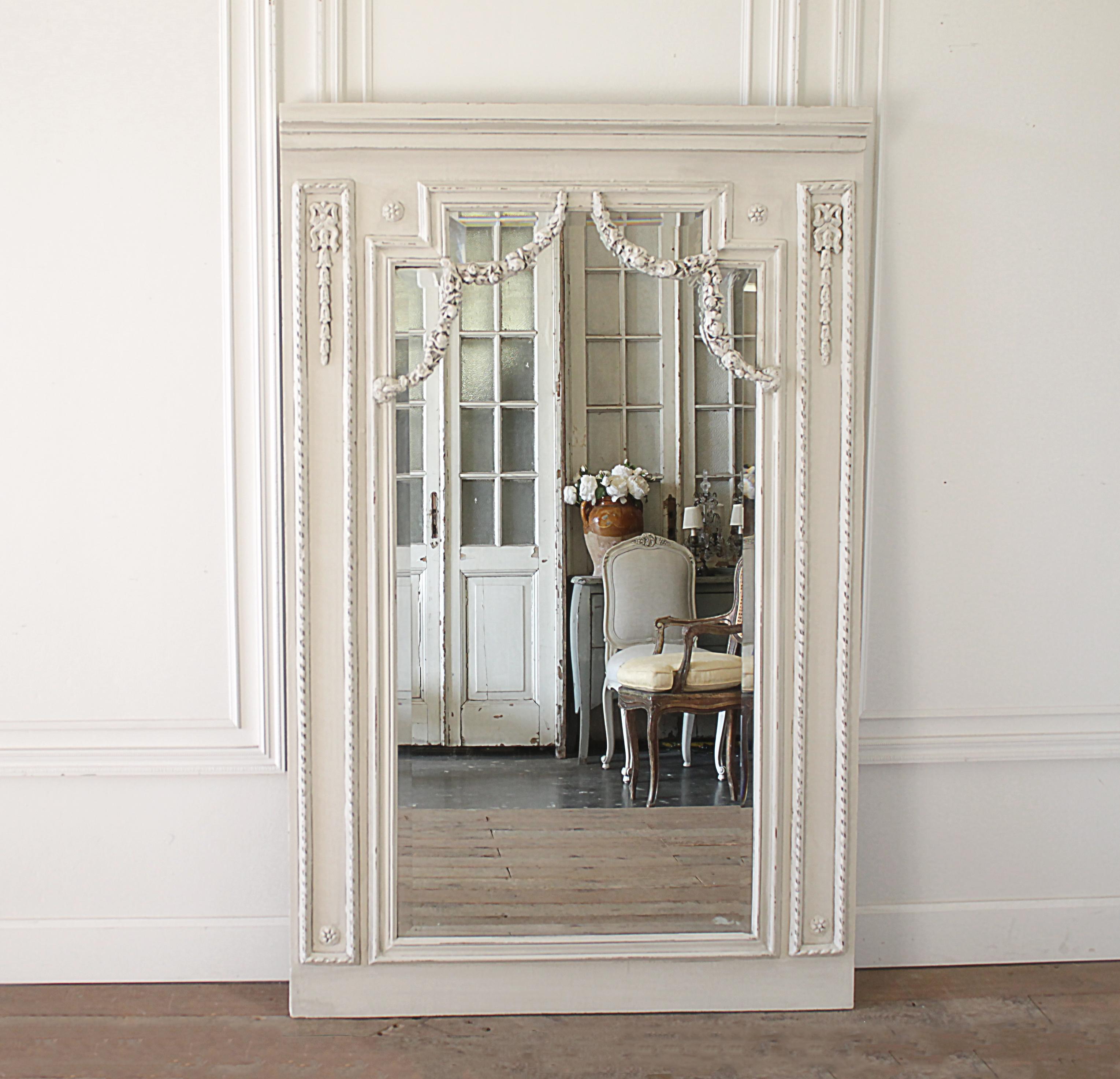 20th century wood Trumeau style carved and painted mirror
Painted in our signature oyster white finish, with subtle distressed edges and finished with an antique glaze. This mirror has large swagging rose garlands draping down over the mirror. The