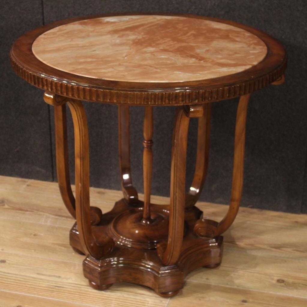Italian side table from the second half of the 20th century. Furniture of beautiful line and construction veneered in walnut, mahogany and fruitwood. Side table with built-in marble top supported by six lateral wooden elements plus a central column