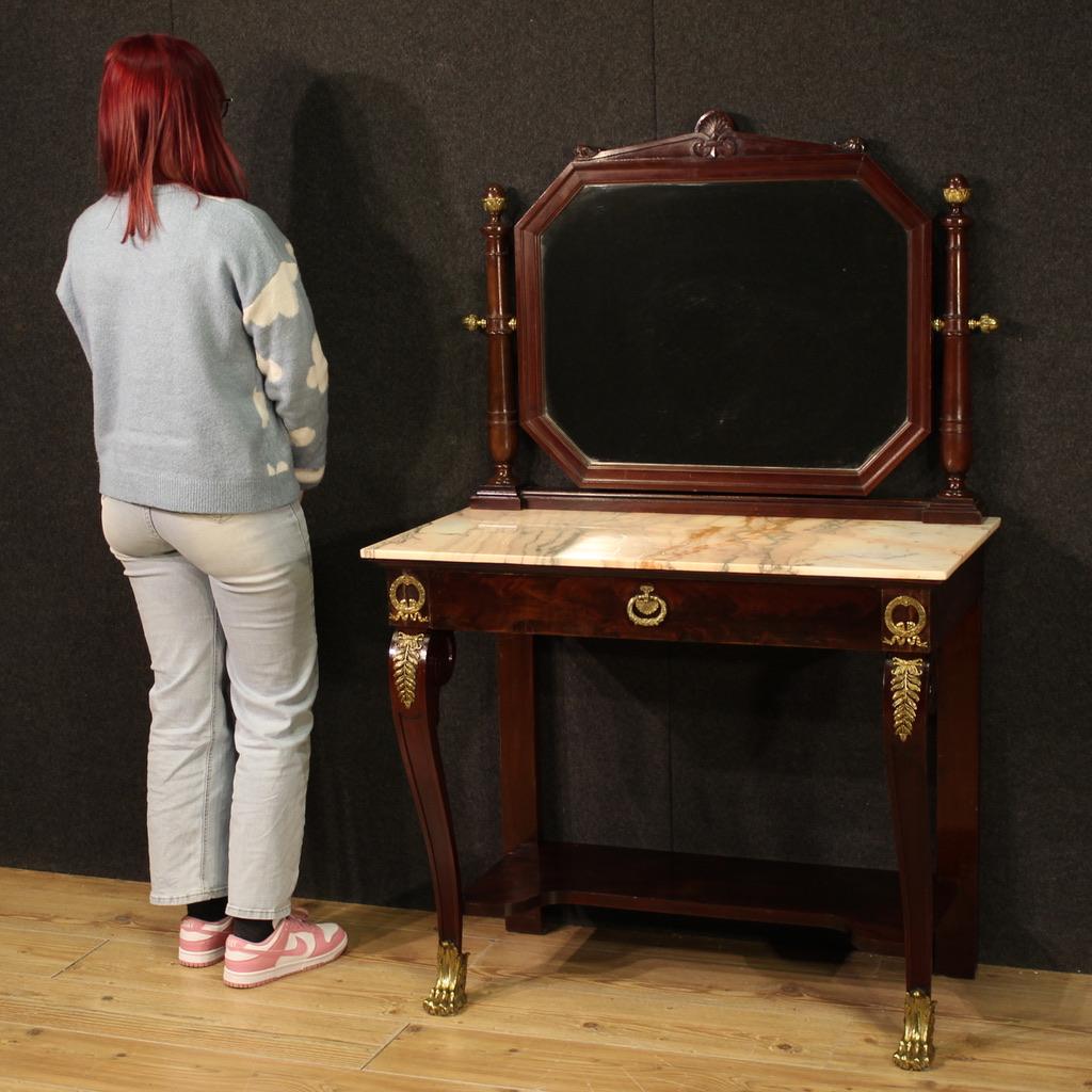 Coiffeuse française de la première moitié du 20e siècle. Acajou sculpté et plaqué de style Empire. Console richement ornée de bronze et de laiton dorés et ciselés. Coiffeuse équipée d'un tiroir frontal de bonne capacité, plateau en onyx d'excellente