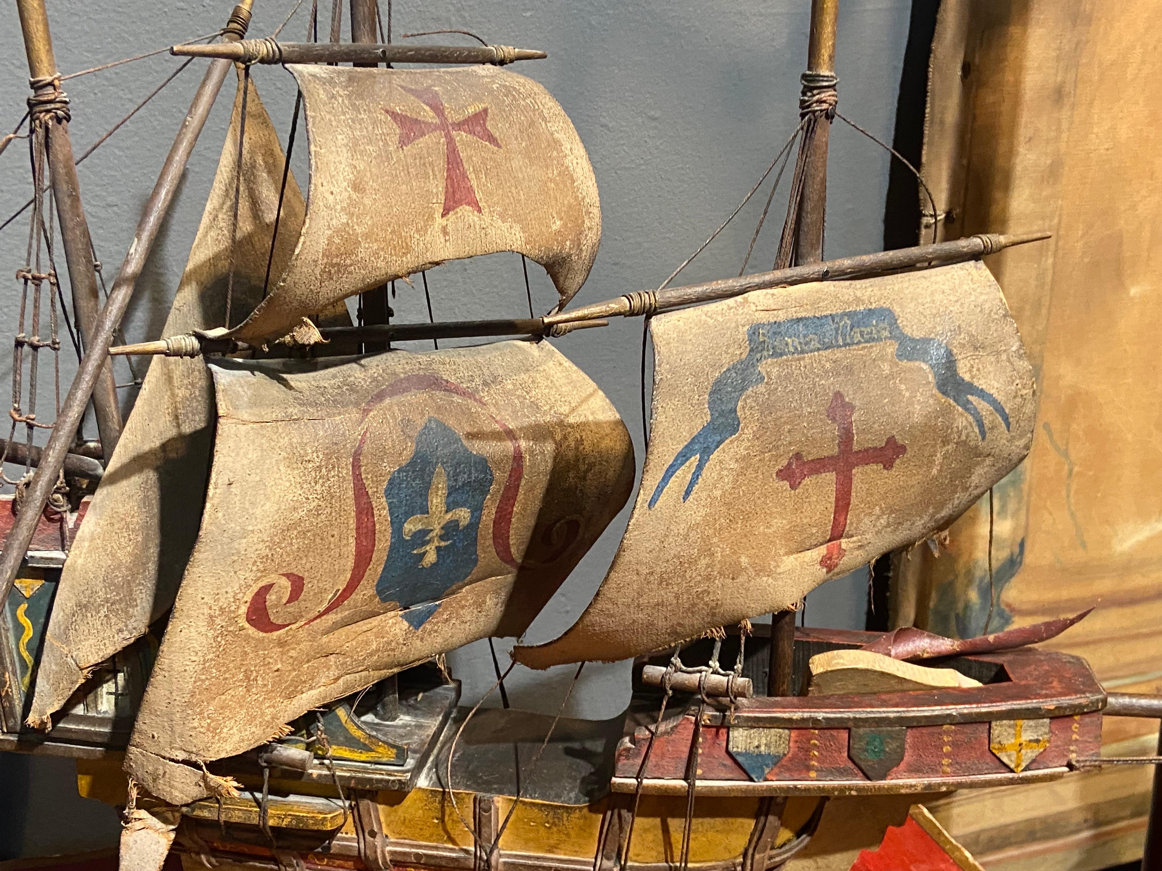 Large hand carved and hand painted caravel ship model standing on a base with three leather sails in fair condition. There are some missing pieces but the overall impression is quite good. The colours are really beautiful and authentic as there are
