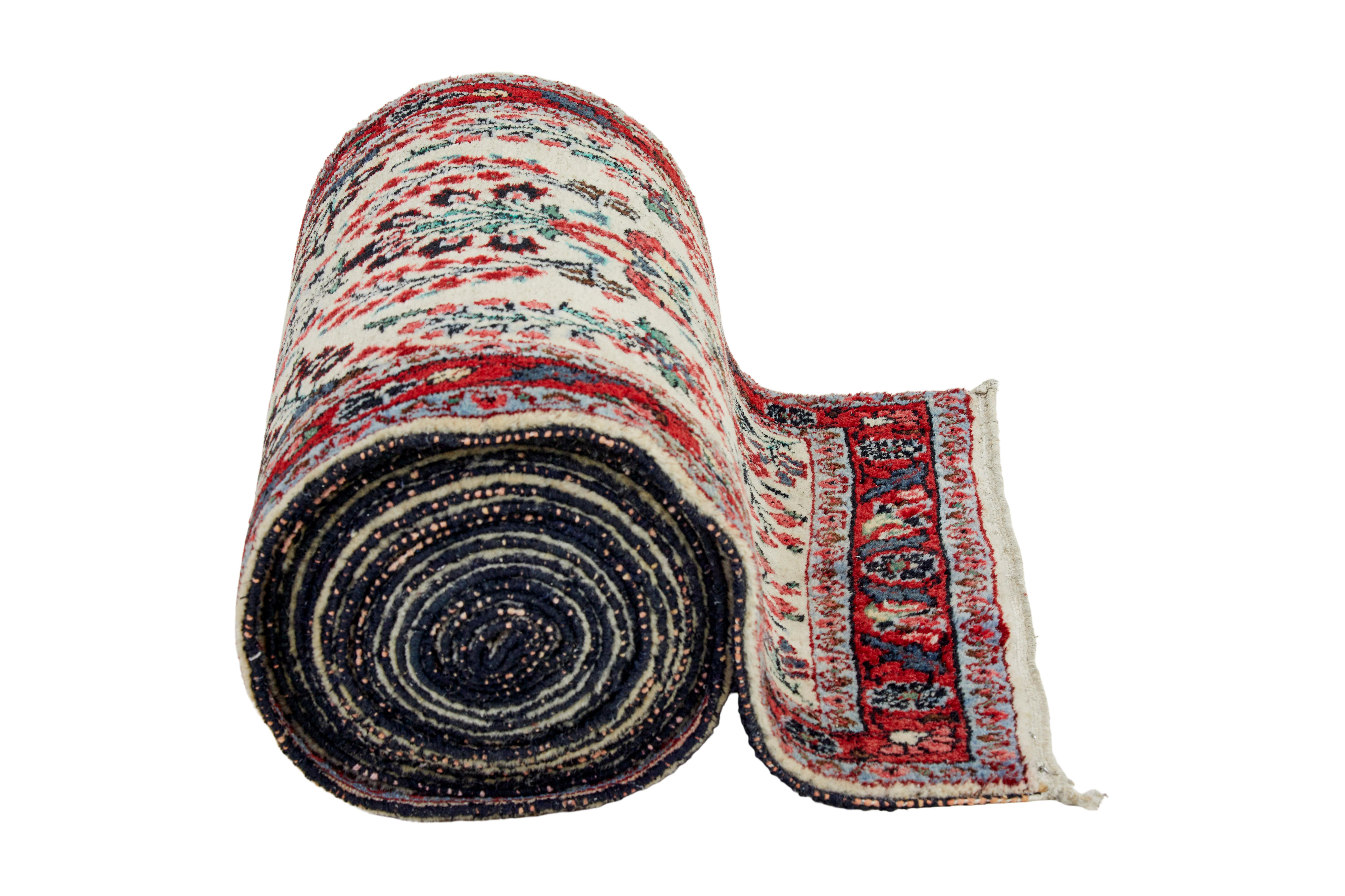 20th century woven asian 31 foot long carpet runner circa 1980.

Beige background with red and green borders. Ideal length for running up stairs. Overall good condition with a few minor losses.

Very very light fading towards one end due to natural