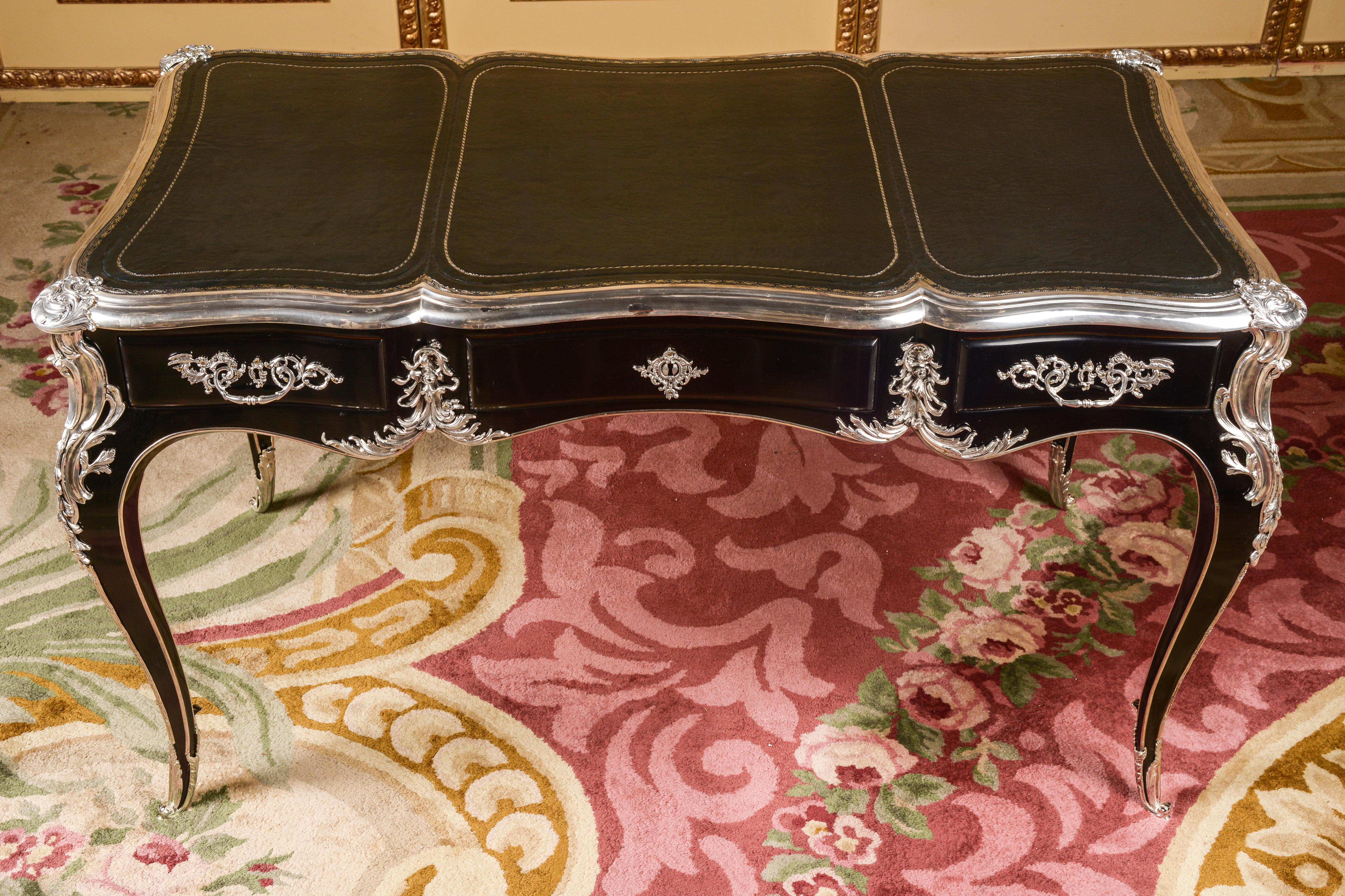 20. Jahrhundert Schreibtisch Louis XV Piano-Schwarz Bureau Plat

Majestic Büroplatte im Stil Louis XV.
Klavierschwarz poliertes Furnier auf massivem Kiefernholz mit Rocaille-Applikationen.
Außergewöhnlich feine florale, versilberte