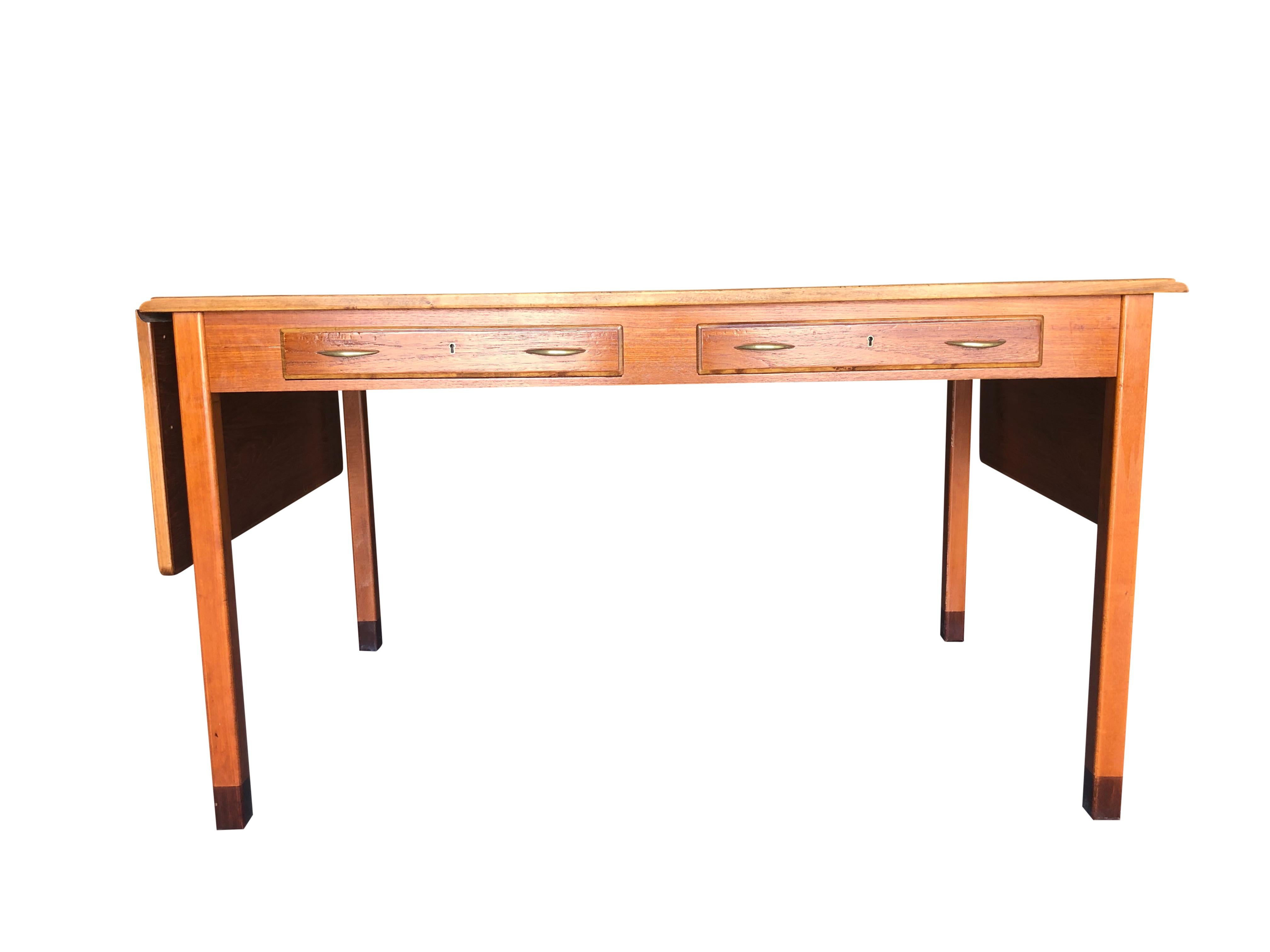 A vintage Mid-Century Modern Swedish writing desk, table or bureau plat designed by David Rosen, produced by Nordiska Kompaniet. This well designed piece of furniture with end extensions is made of hand crafted polished Teakwood, enhanced by brass