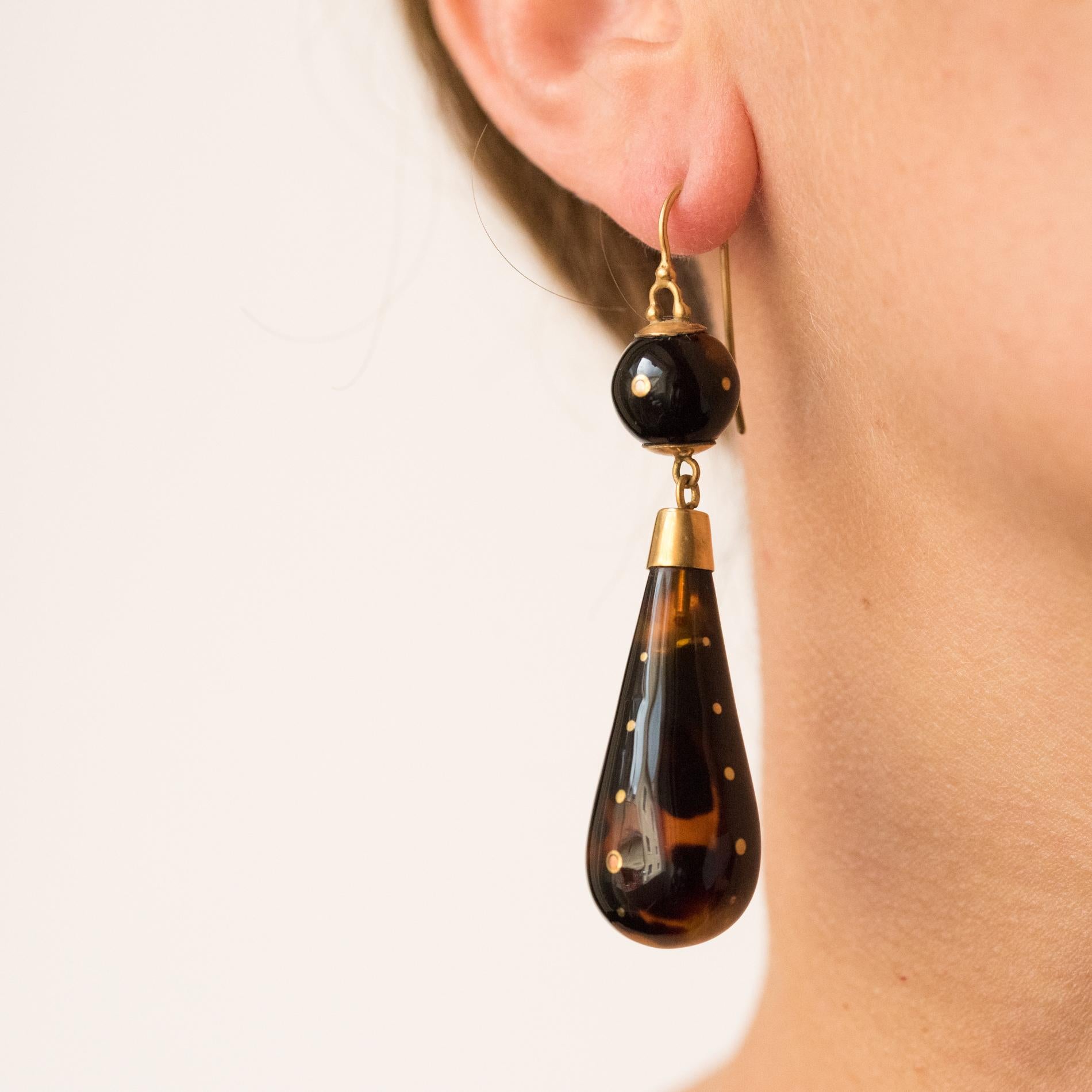 Brown tortoiseshell earrings. 
These antique earrings are made of a tortoiseshell pearl studded with gold nails and which retains in pendant a drop pattern also in tortoiseshell with gold nail. The clasp is a gooseneck in 14 karats yellow