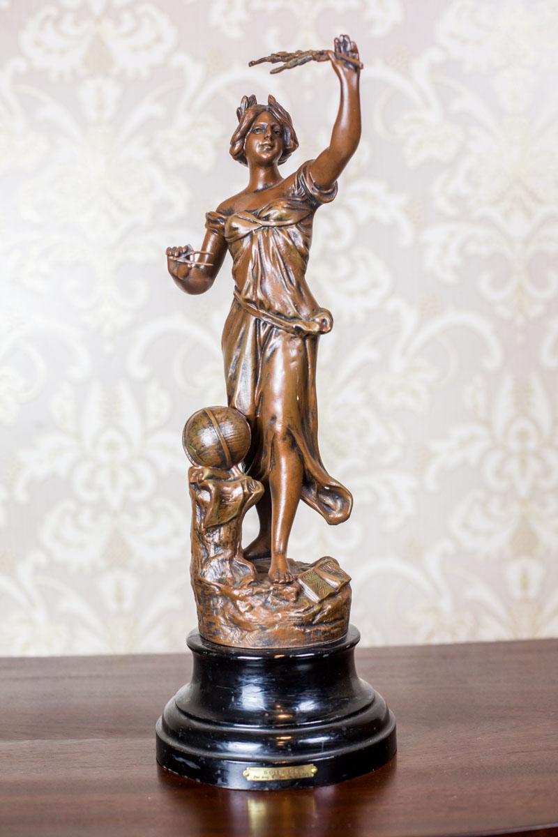 We present you this bronzed Zamak figurine depicting personified Scientia, dated first quarter of the 20th century.
The figure is placed on a metal pedestal painted black.
The cast is based on a project by Auguste Moreau. The name of the casting