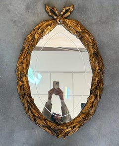 Miroir ovale en bois doré d'époque Empire, 20e siècle