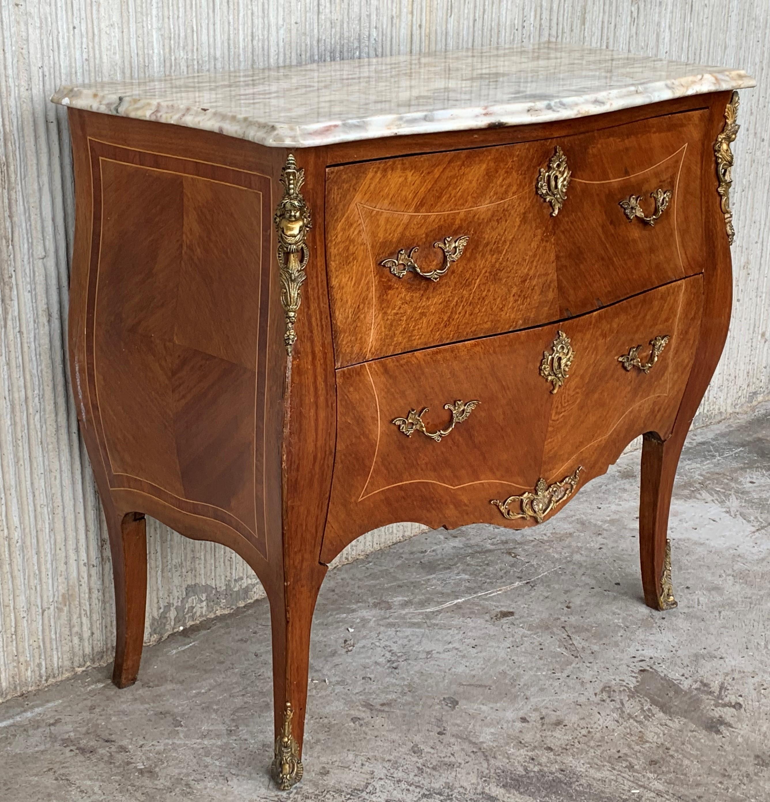 A fine Louis XV two-drawer commode with Breche d’Alep marble conforming top in shades of pink and grey with molded edge and notched corners, all with rosewood and tulipwood crossbanding and the bombe case is decorated with kingwood and rosewood
