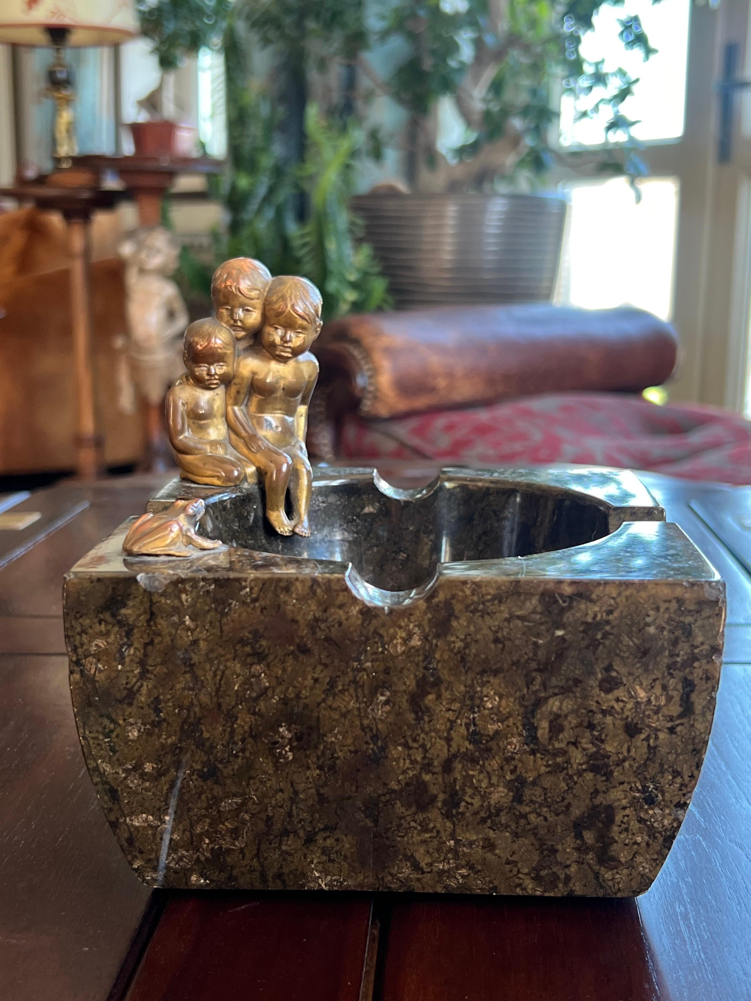 20th French ashtray made of solid granit stone in dark brown, elegantly decorated with a sculpture of three bronze figures of young kids watching a small frog on the other side. Pretty heavy piece in very good condition.
France, circa 1920