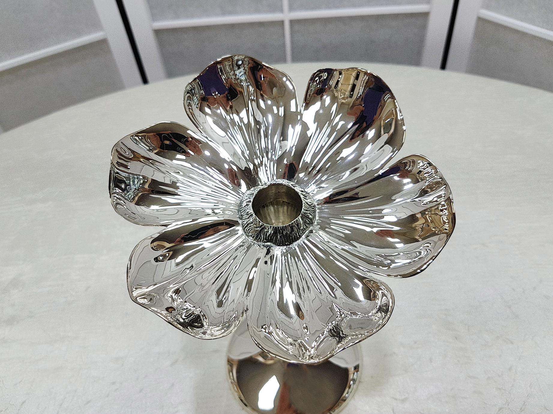 Bellissimo lampadario a 1 fiamma in argento massiccio con la parte superiore che riproduce la corolla di un fiore. Il gambo come la base rotonda è liscio e lucido.