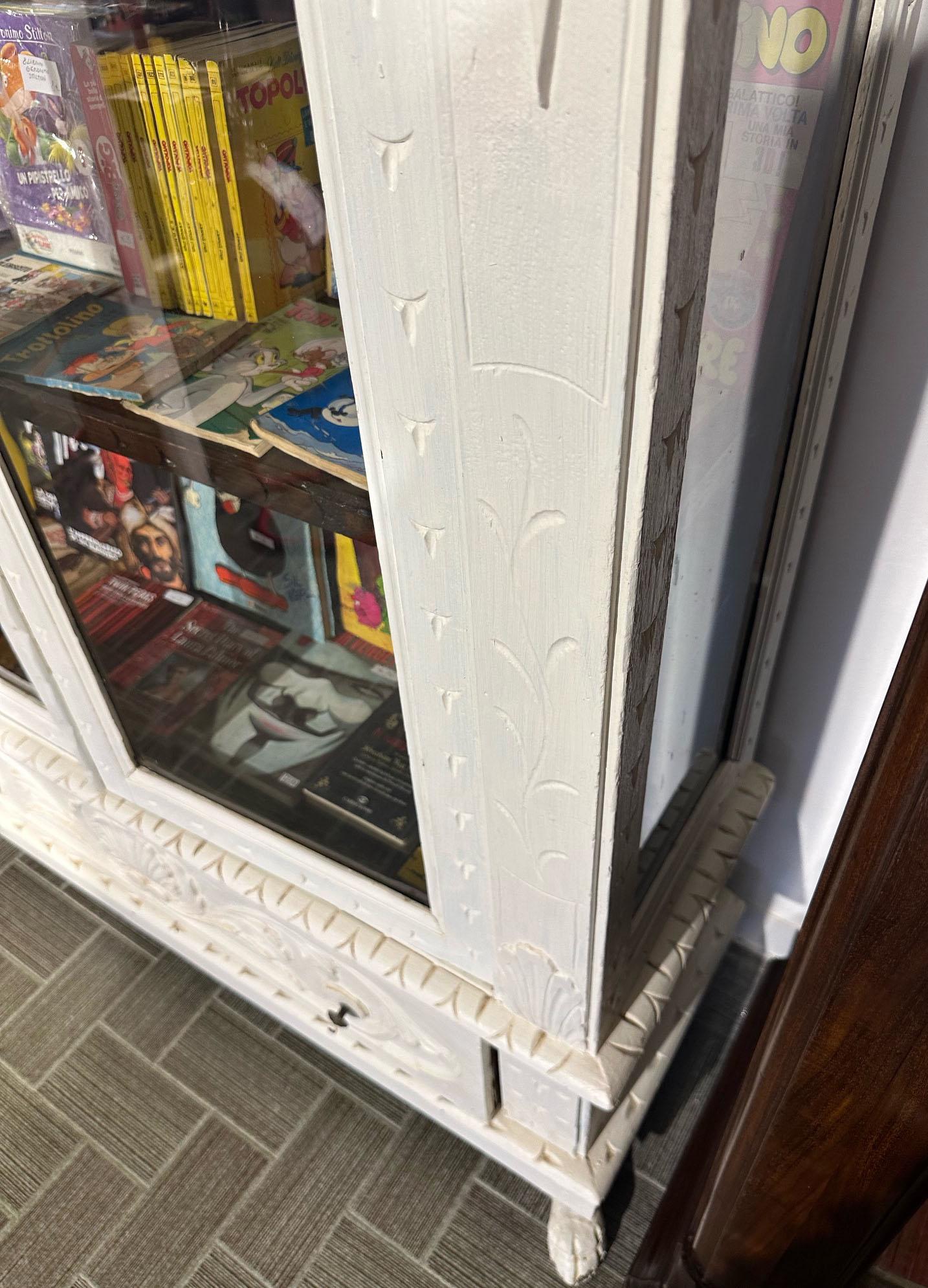 Italian Renaissance style display cabinet of 1900 original in hand-carved solid ebonized fir, with two original glass doors of the time. 
Patinated cream white color.
Three internal shelves and drawer. 
Shellac and wax finish.
Comes from an old