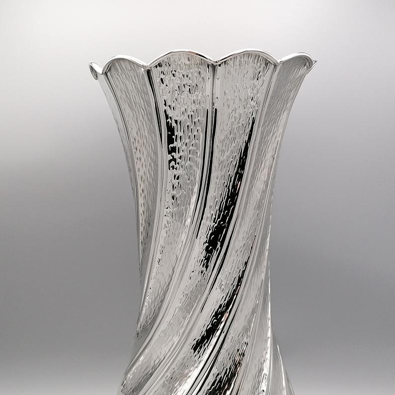 Vase élégant et raffiné en argent sterling. 
Entièrement réalisé à la main et embossé d'un motif de torchon, le vase a été finement martelé sur tout le corps. 
L'embouchure du vase est en forme de vagues et bordée d'un fil d'argent.
L'orfèvrerie