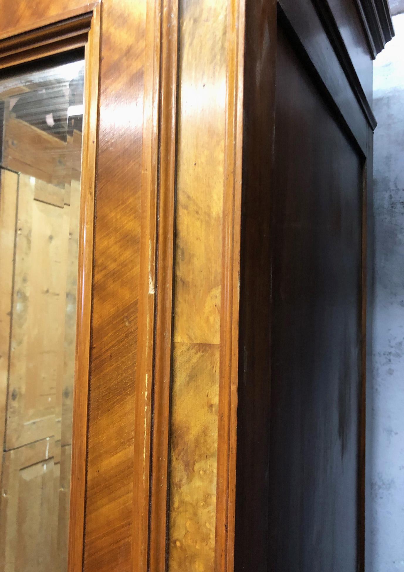 Italian wardrobe with one door in walnut with mirror and external drawer. 
It is easily disassembled into a few pieces and reassembled in 15 minutes.
It's very practical. 
Given the weight of the door with mirror, I recommend fixing the wardrobe