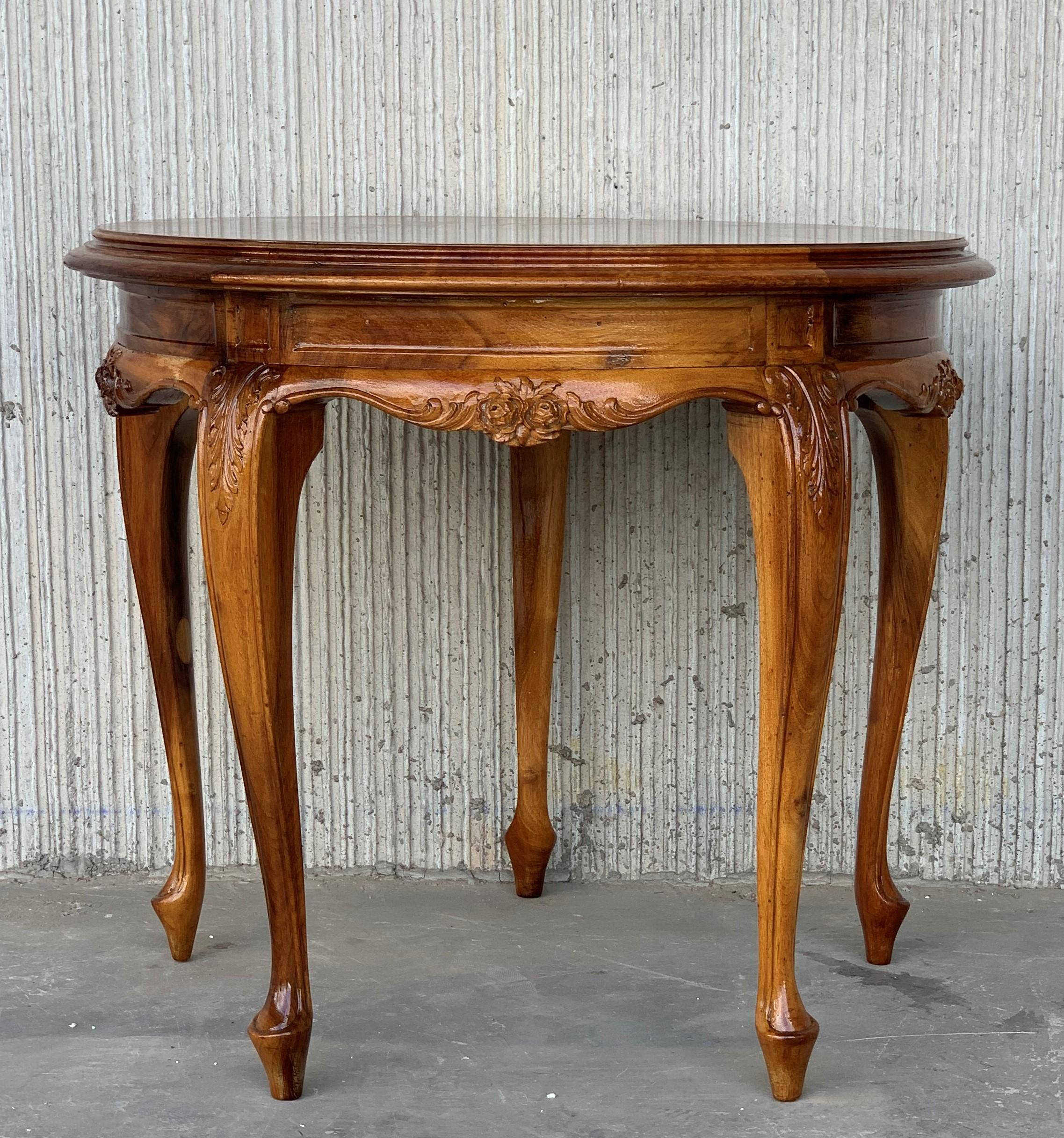 An Italian Rococo style round side table with burl top over a richly carved base from the 20th century. The apron is adorned on all sides with typical Mariano Garcia motifs.
The table is on four cabriole legs with scrolled feet, adorned with