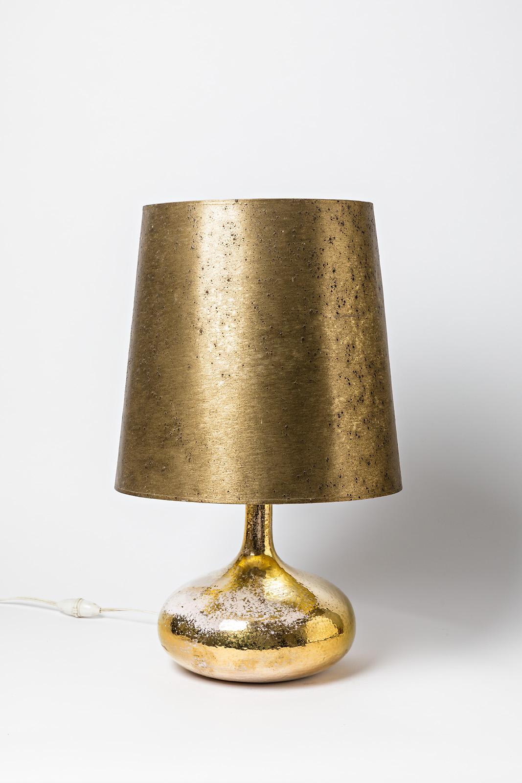 Elegant golden ceramic table lamp.

Realised circa 1975, French handmade production.

Original lamp shade.

Beautiful shinny gold ceramic glaze and white color effects.

Electric system is ok

sold with the original lamp shade,

circa