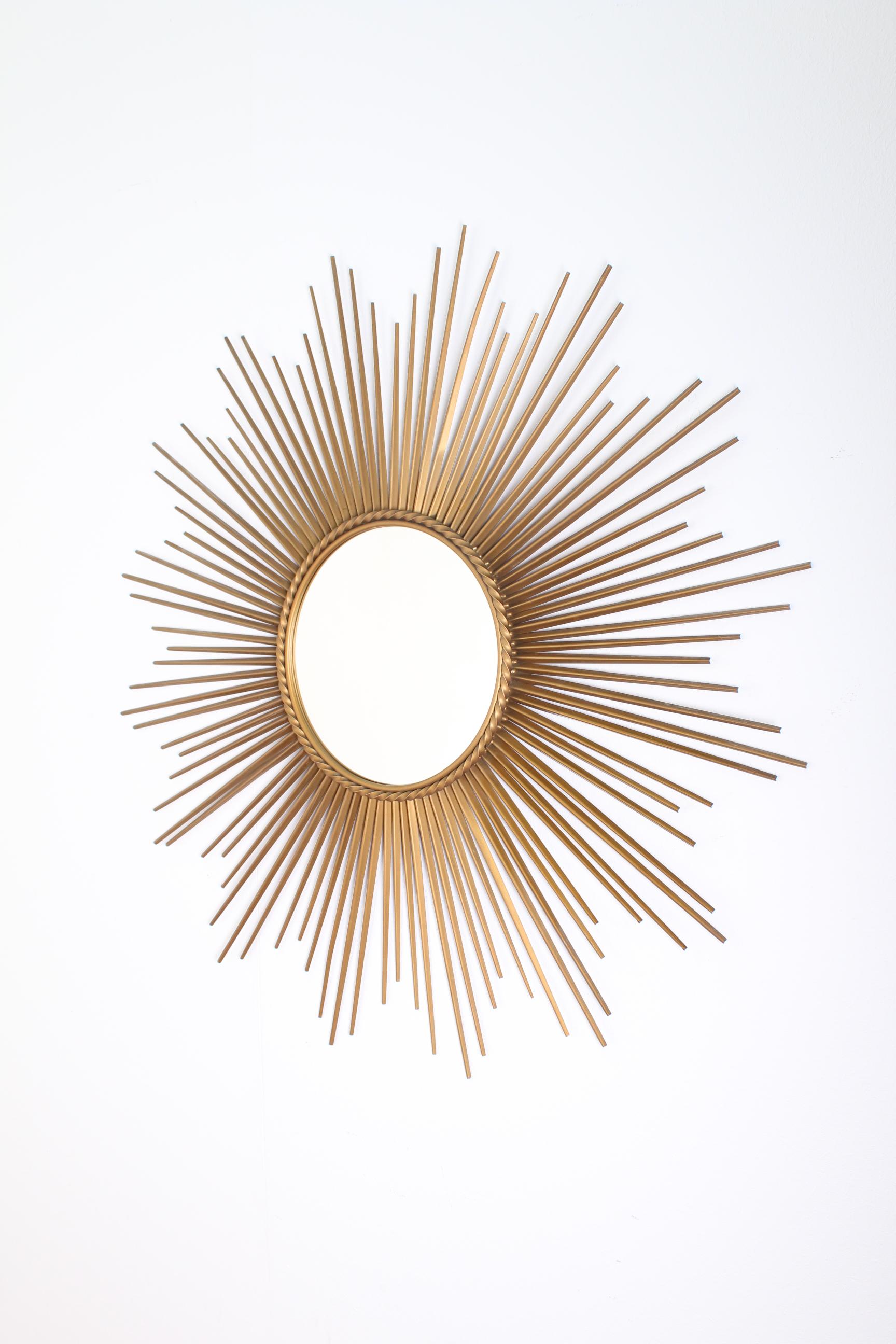 Elegant and beautiful gilded metal framed sunburst mirror made in the 1960s in France by Chaty Vallauris. Very elegant and in very good condition. With mirrored glass center in molded frame with rope motif trim.
 Wear consistent with age and use.