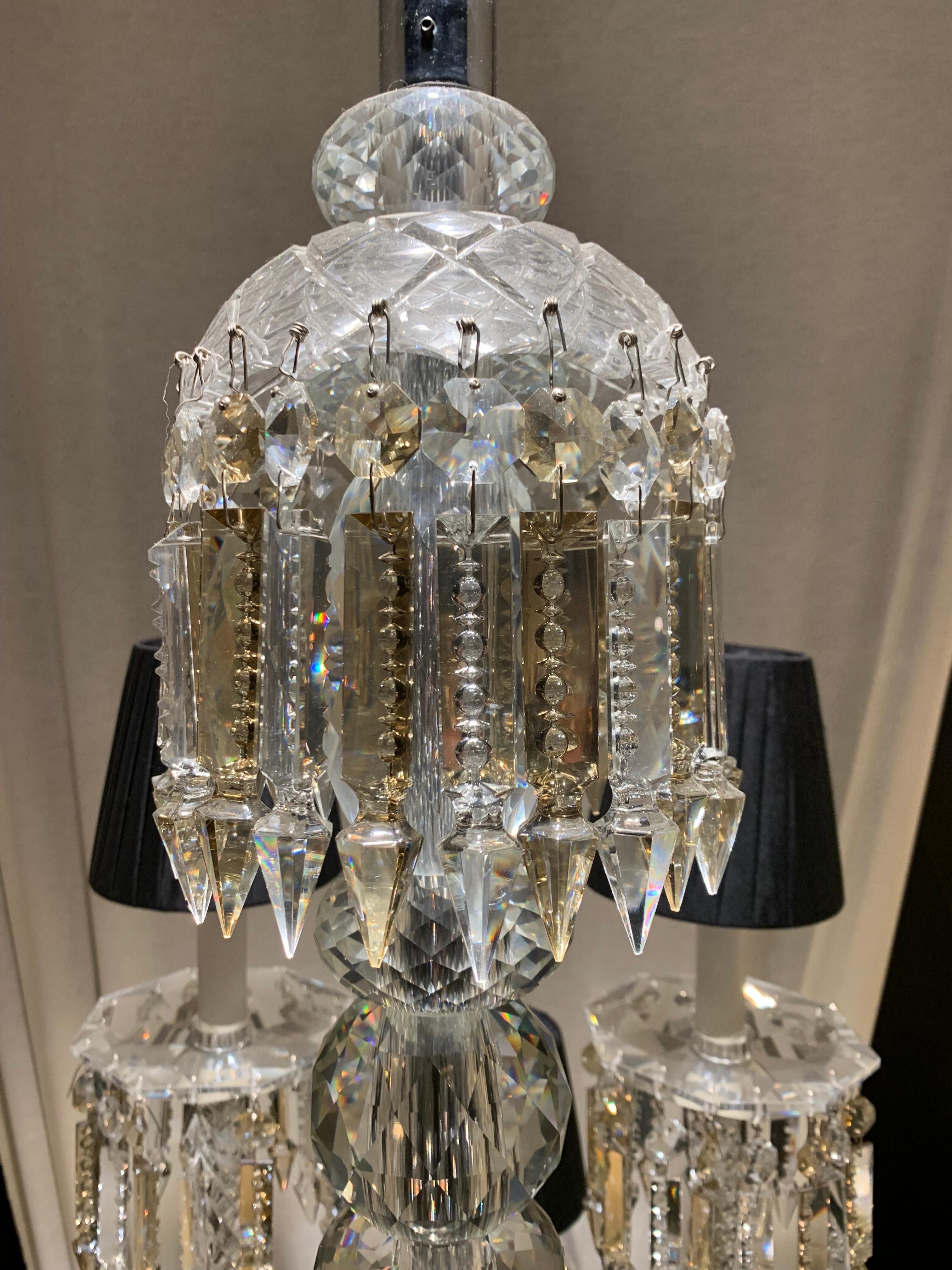 This oval chandelier is made of solid and hand cut crystal. 
It is divided into two floors. The arms of lights are in twisted glasses. The central barrel is in chromed metal covered by crystal parts.
The drops are alternated between an clear shade